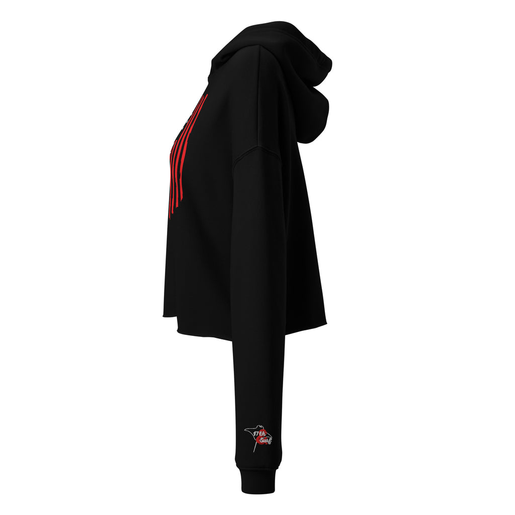 Woman wearing the black "1776 & Surf" crop hoodie, side view, showing the distressed red stripe graphic on the front and the embroidered '17th & Surf' logo on the sleeve cuff – America's 250th Anniversary Collection by 17th & Surf
