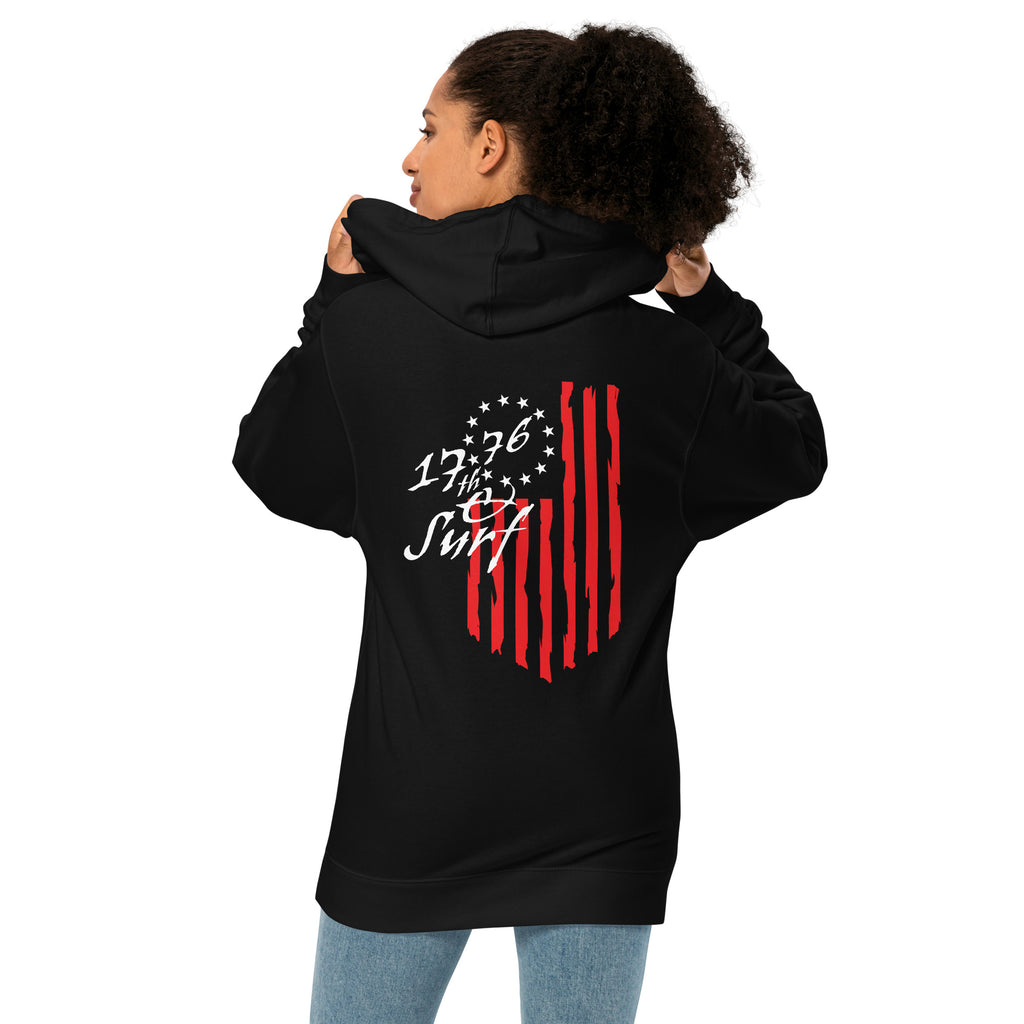 Woman wearing the black "1776 & Surf" hoodie, back view, featuring the large 1776 script logo with 13-star Betsy Ross flag and distressed red stripe graphic – America's 250th Anniversary Collection by 17th & Surf