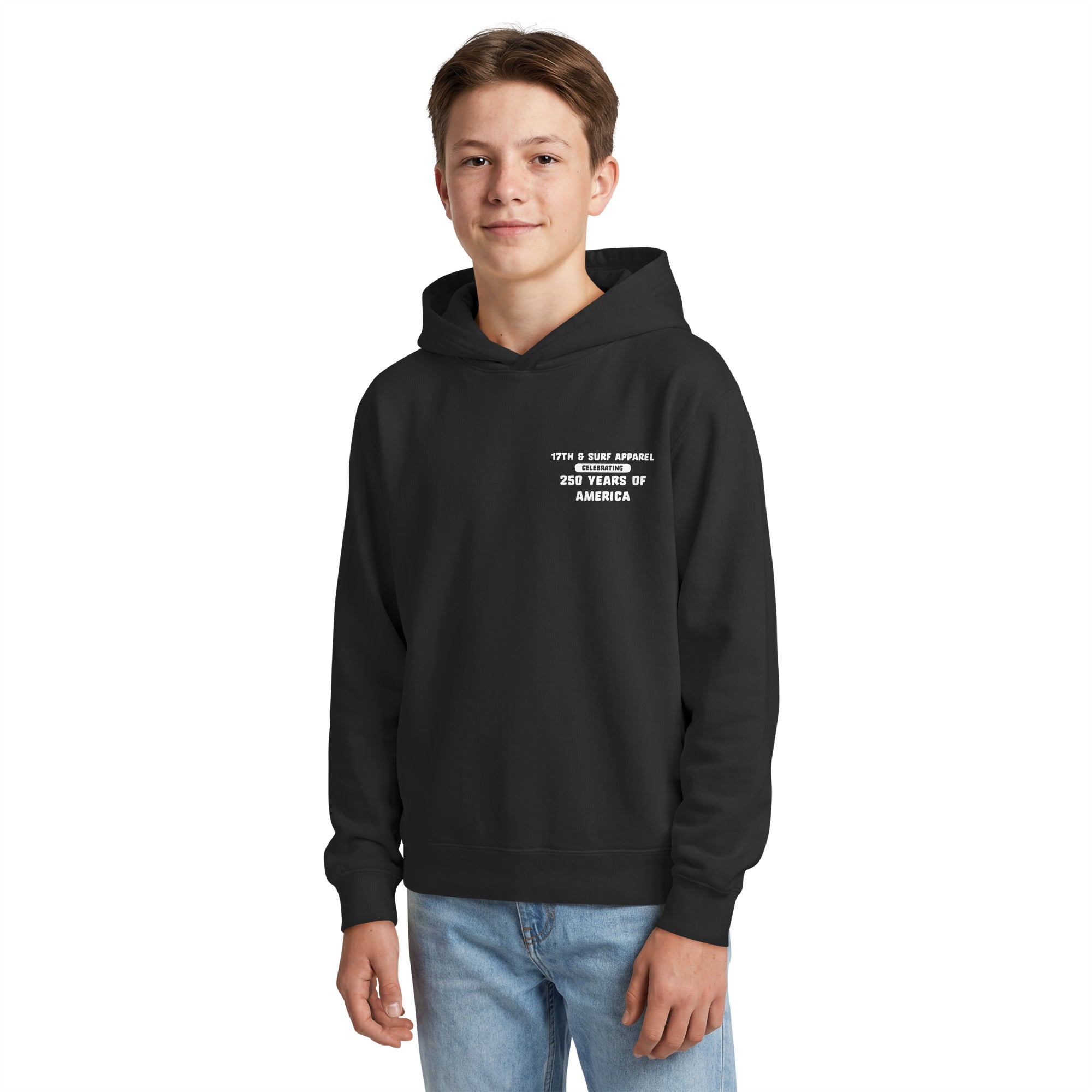 Boy wearing the black "1776 & Surf" kid's hoodie, front view, featuring the small '17TH & SURF APPAREL Celebrating 250 Years of America' chest wordmark – America's 250th Anniversary Collection by 17th & Surf