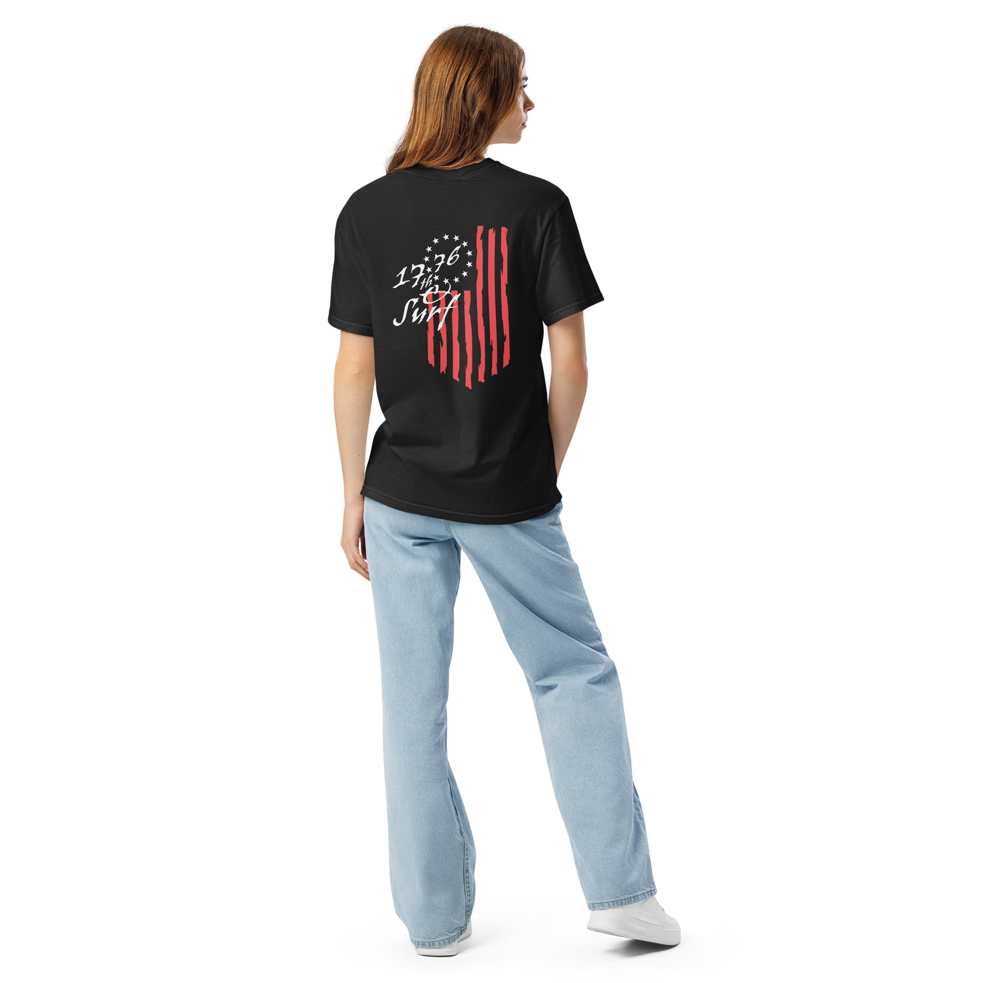 Woman wearing the black "1776 & Surf" tee, back view, featuring the large 1776 script logo with 13-star Betsy Ross flag and distressed red stripe graphic – America's 250th Anniversary Collection by 17th & Surf