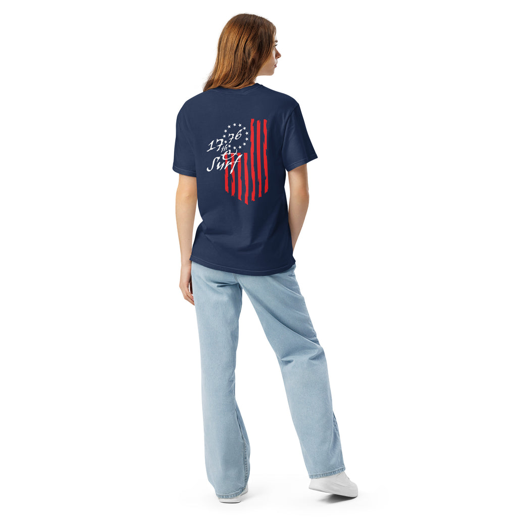 Woman wearing the navy "1776 & Surf" tee, back view, featuring the large 1776 script logo with 13-star Betsy Ross flag and distressed red stripe graphic – America's 250th Anniversary Collection by 17th & Surf