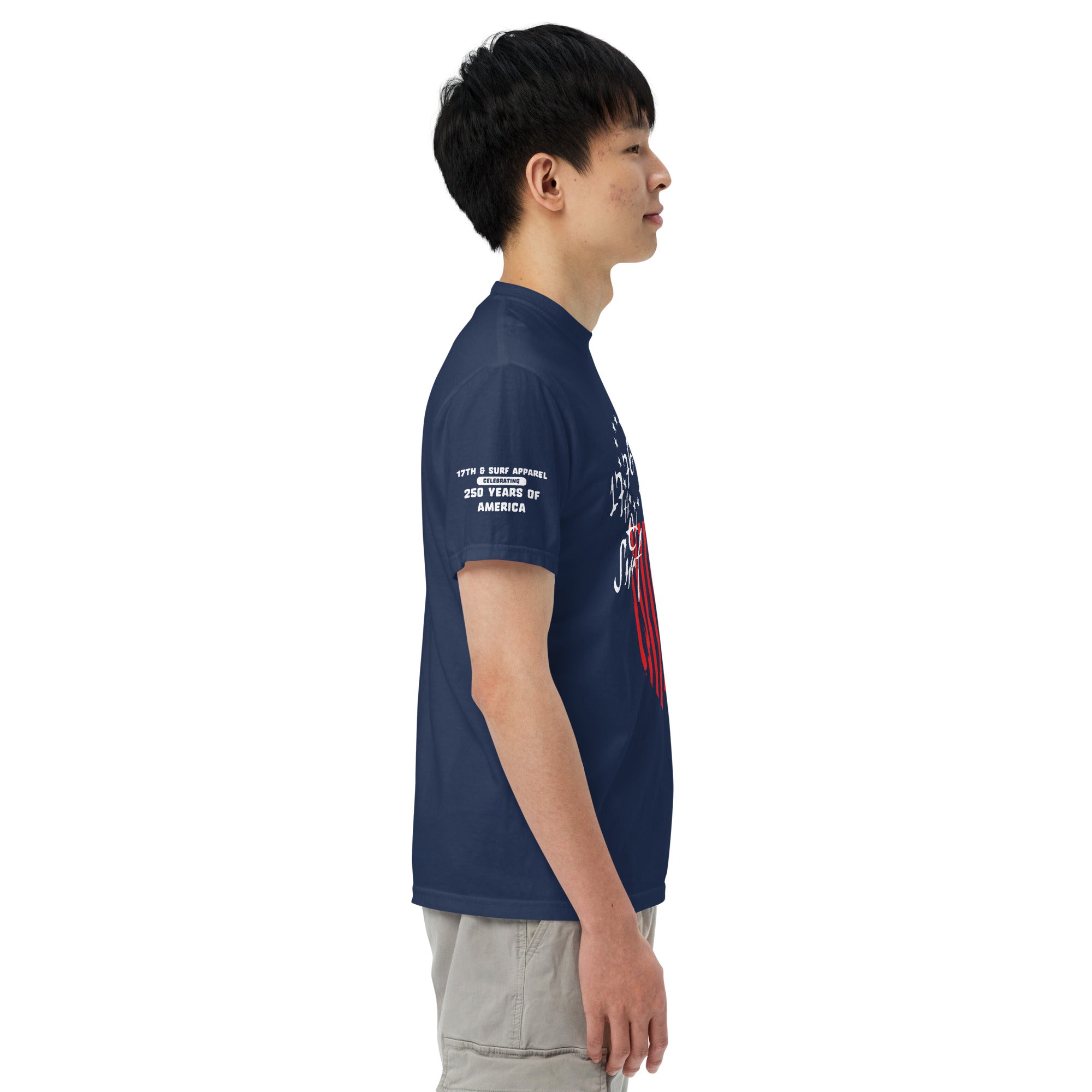 Man wearing the navy "1776 & Surf" tee - front print, right-side view, showing the 1776 script logo with 13-star Betsy Ross flag graphic and the 'Celebrating 250 Years of America' sleeve text – America's 250th Anniversary Collection by 17th & Surf