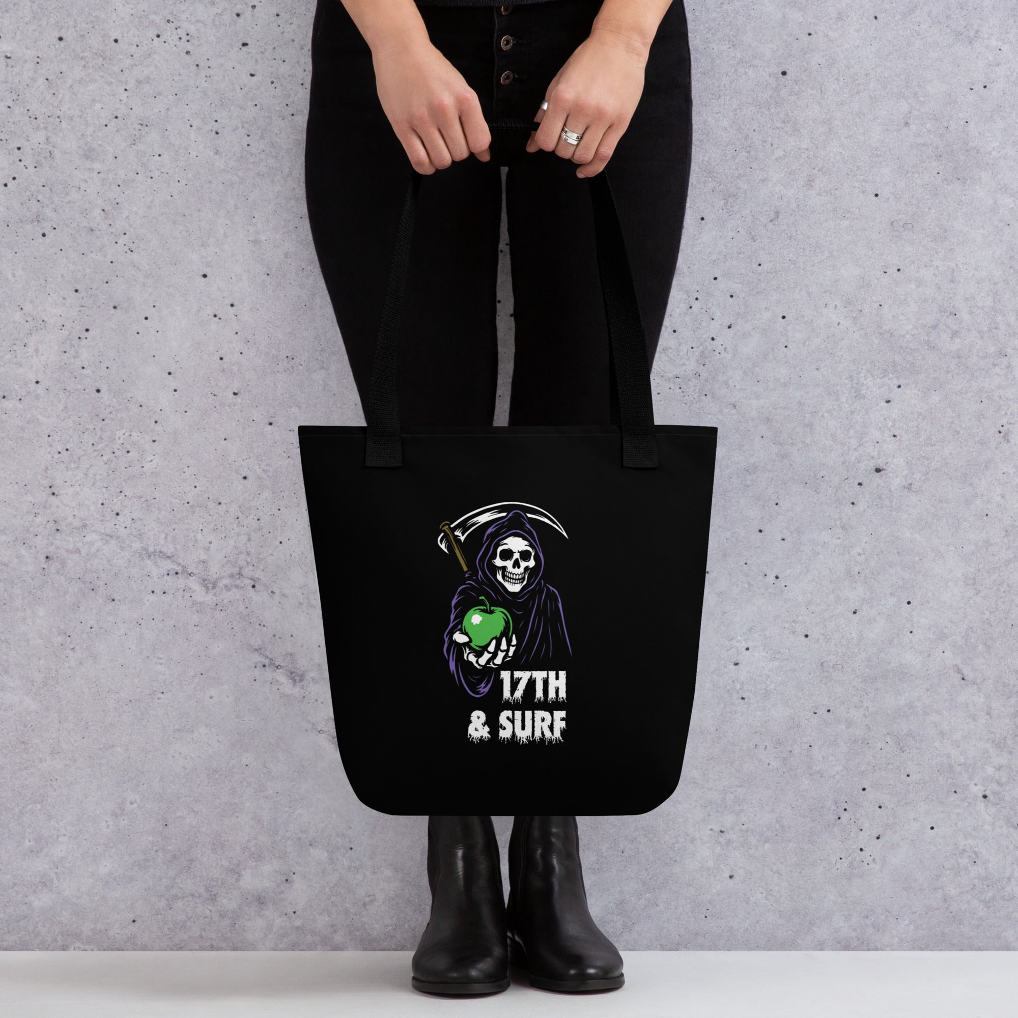 "Beach Apple" black canvas tote bag, back view on model, featuring the small "17th & Surf" Grim Reaper apple logo – "Beach Apple" Series by 17th & Surf