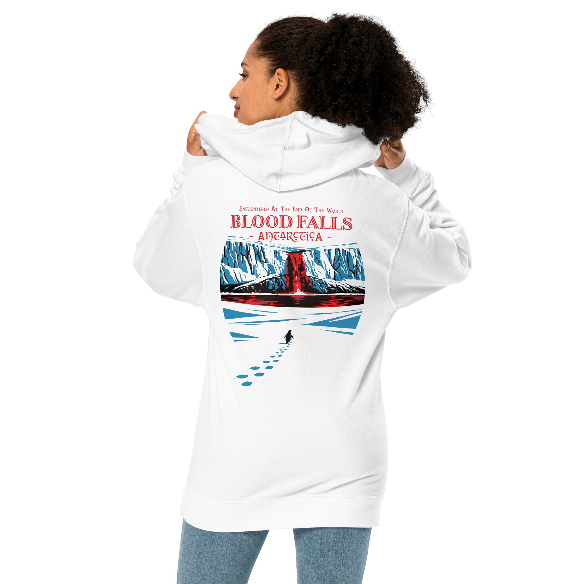 Female model wearing "Blood Falls" Antarctica hoodie featuring a lone penguin walking toward a red waterfall through icy glacier cliffs – Haunted Seas Series by 17th & Surf