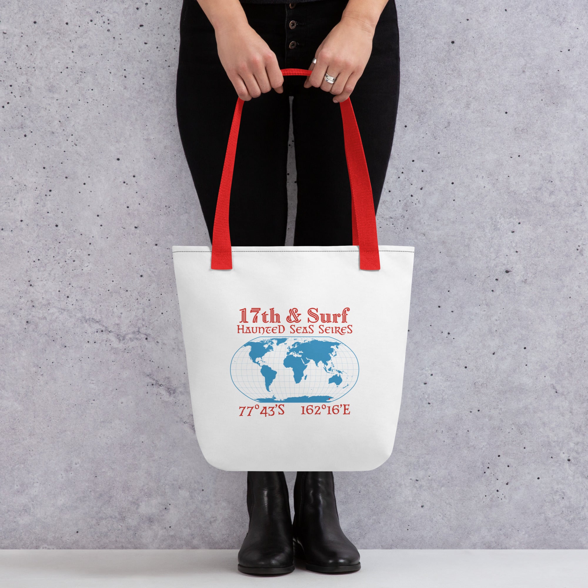 "Blood Falls" Antarctica tote bag, held by model showing back panel, featuring a globe graphic centered on Antarctica with the coordinates 77°43′S 162°16′E marking the Taylor Glacier site – Haunted Seas Series by 17th & Surf