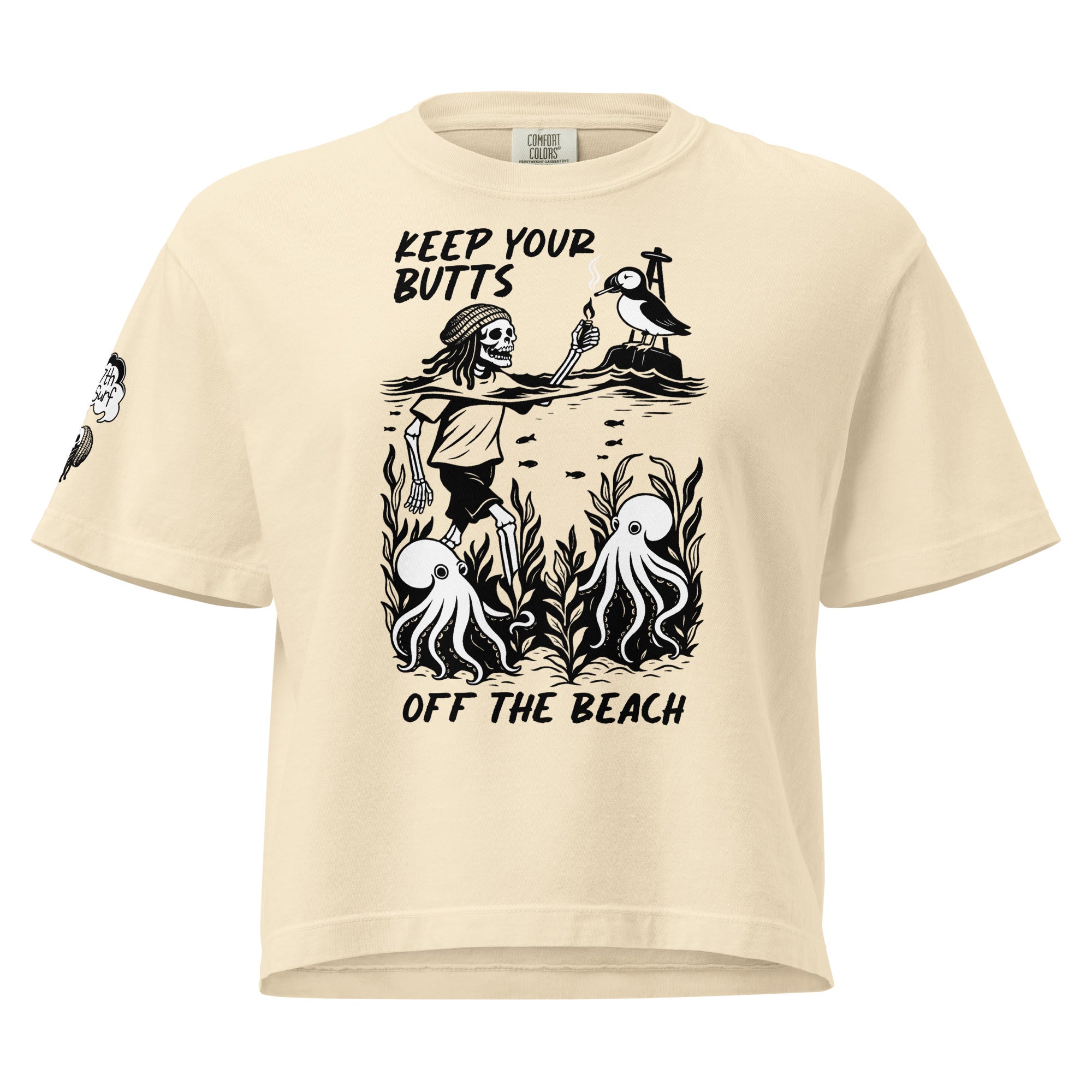 "Keep Your Butts Off The Beach" women's heavyweight boxy tee front view in ivory featuring skeleton lighting a cigarette for a puffin with octopuses in seaweed graphic and small smoking-skull sleeve logo - 17th & Surf