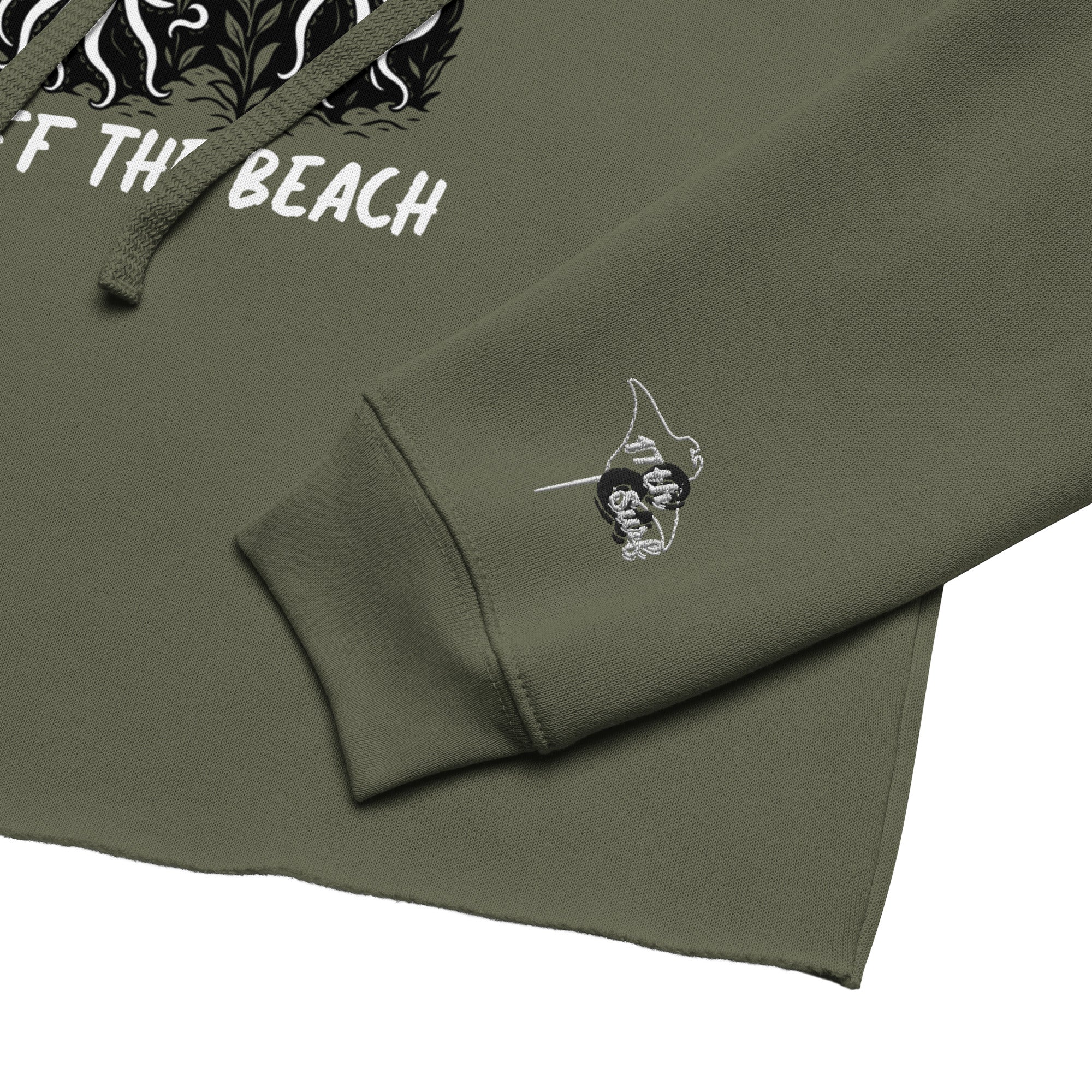 "Keep Your Butts Off The Beach" cropped hoodie in military green, sleeve cuff close-up, featuring the embroidered "17th & Surf" stingray logo with the smoking skeleton and puffin graphic visible in the background – 17th & Surf