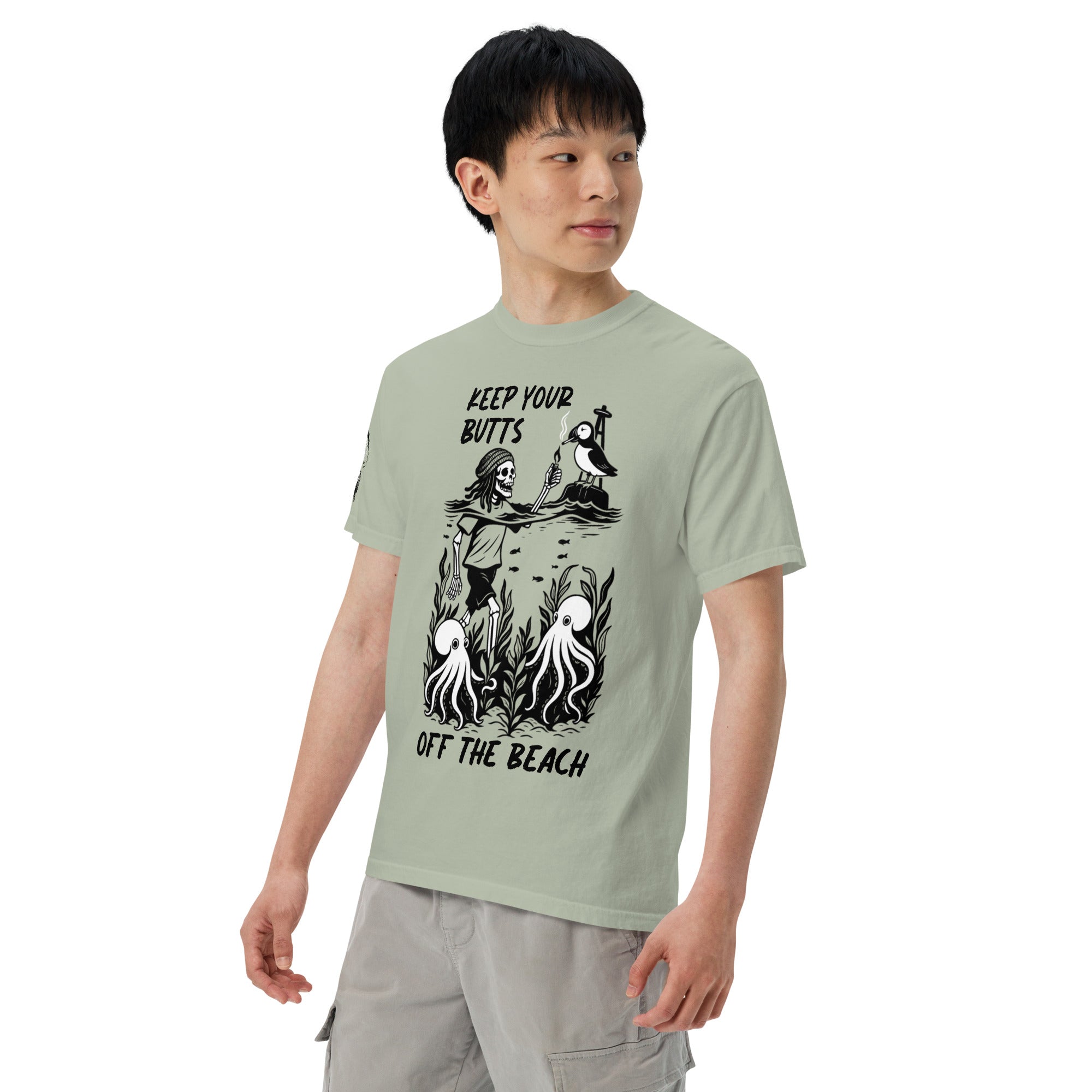 "Keep Your Butts Off The Beach" front print garment-dyed heavyweight tee left front angle in bay showing skeleton lighting a cigarette for a puffin with octopuses in seaweed graphic - 17th & Surf