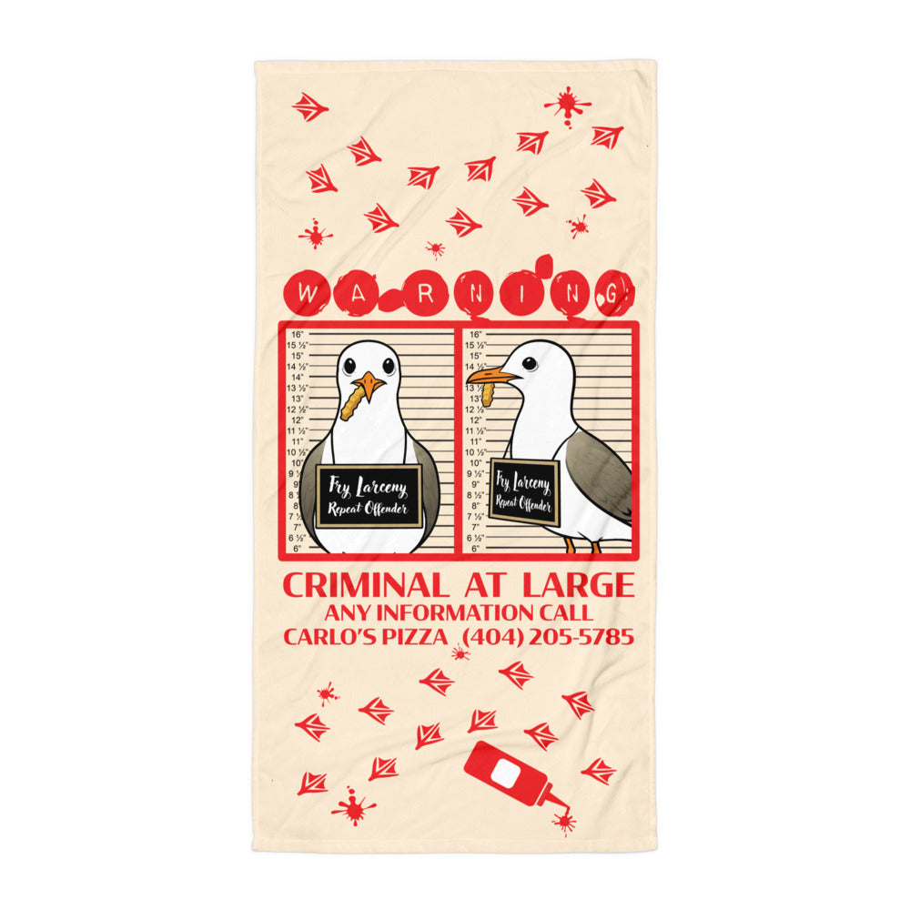 "Criminal At Large" cream beach towel flat lay, featuring seagull "WARNING" mugshot graphic, red footprint trail, and Carlo's Pizza ketchup bottle design – 17th & Surf