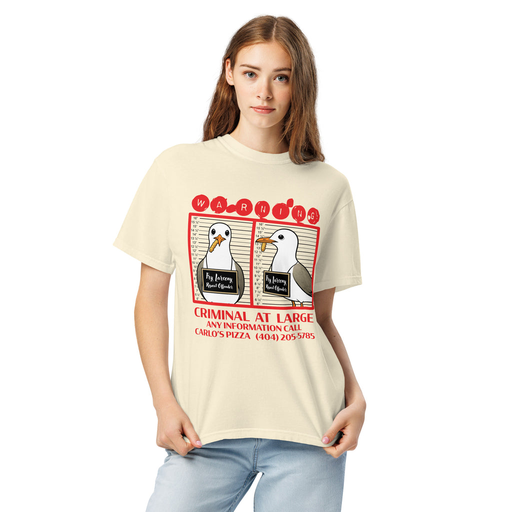 "Criminal At Large" ivory garment-dyed heavyweight tee on female model, front view, featuring seagull "WARNING" mugshot graphic with "Fry Larceny, Repeat Offender" police lineup – 17th & Surf x Carlo's Pizza