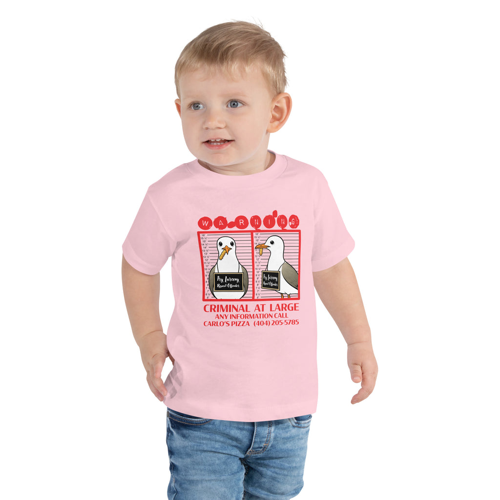 "Criminal At Large" pink toddler tee, front flat lay, featuring seagull "WARNING" mugshot graphic with "Fry Larceny, Repeat Offender" police lineup – 17th & Surf x Carlo's Pizza