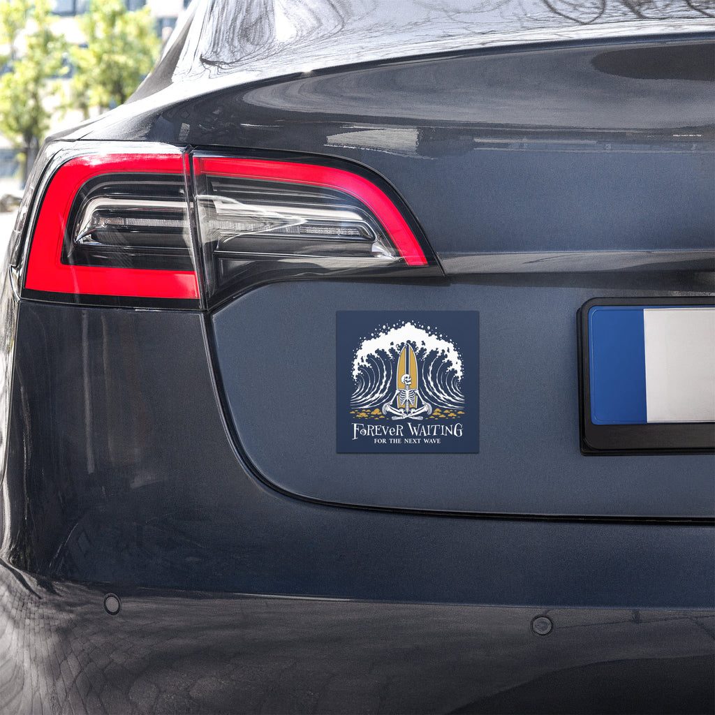 "Forever Waiting For The Next Wave" car magnet, second front view, featuring a meditating skeleton surfer, board planted upright behind him, sitting cross-legged on the shore as breakers roll in on either side – 17th & Surf