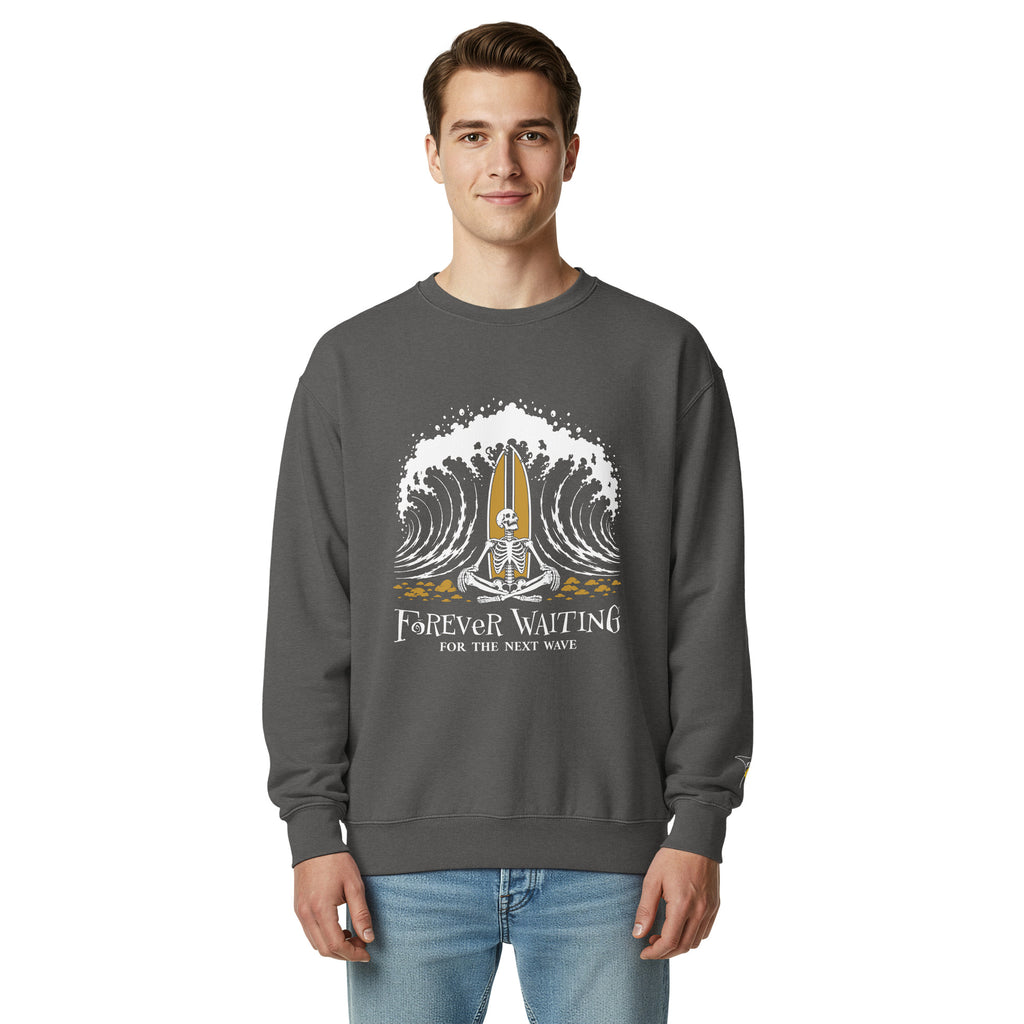 "Forever Waiting For The Next Wave" crewneck sweatshirt, Pepper, second front view, featuring a meditating skeleton surfer, board planted upright behind him, sitting cross-legged on the shore as breakers roll in on either side – 17th & Surf