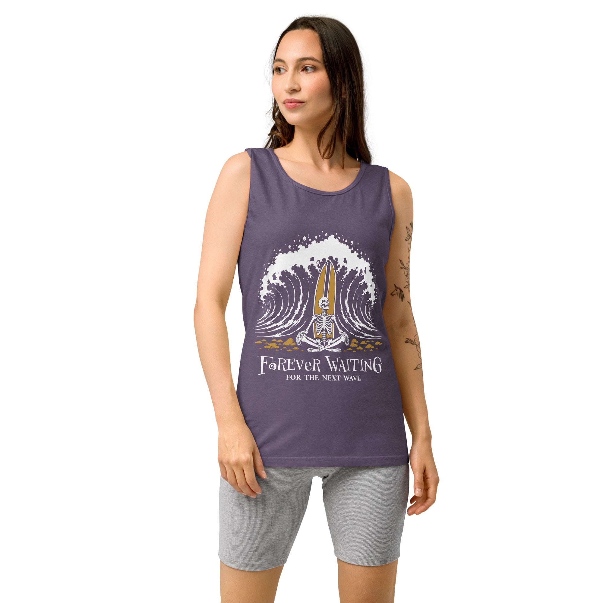 "Forever Waiting For The Next Wave" tank top, Grape, third front view, featuring a meditating skeleton surfer, board planted upright behind him, sitting cross-legged on the shore as breakers roll in on either side – 17th & Surf