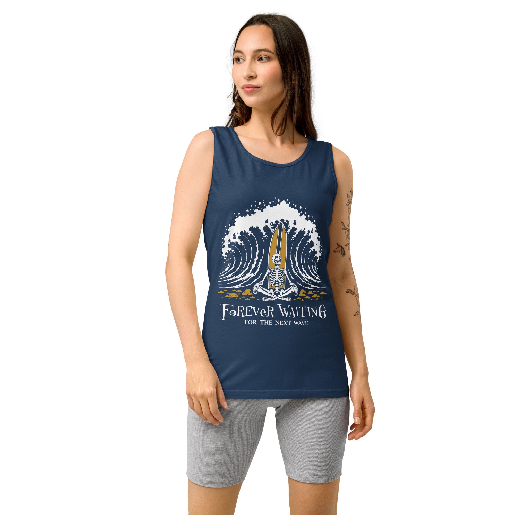 "Forever Waiting For The Next Wave" tank top, True Navy, third front view, featuring a meditating skeleton surfer, board planted upright behind him, sitting cross-legged on the shore as breakers roll in on either side – 17th & Surf