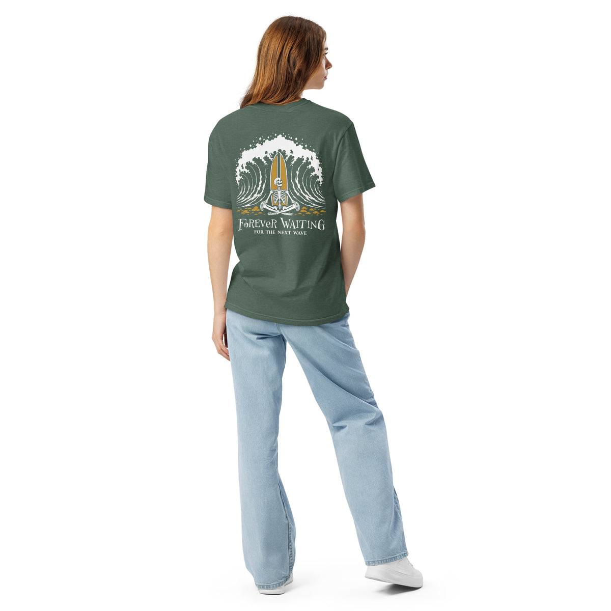 "Forever Waiting For The Next Wave" tee, Blue Spruce, second back view, featuring a meditating skeleton surfer, board planted upright behind him, sitting cross-legged on the shore as breakers roll in on either side – 17th & Surf