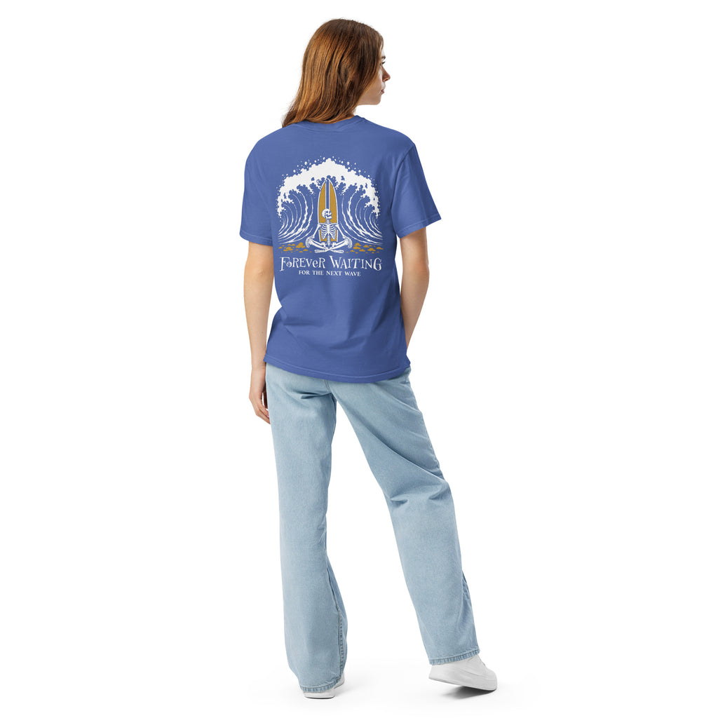 "Forever Waiting For The Next Wave" tee, Mystic Blue, second back view, featuring a meditating skeleton surfer, board planted upright behind him, sitting cross-legged on the shore as breakers roll in on either side – 17th & Surf
