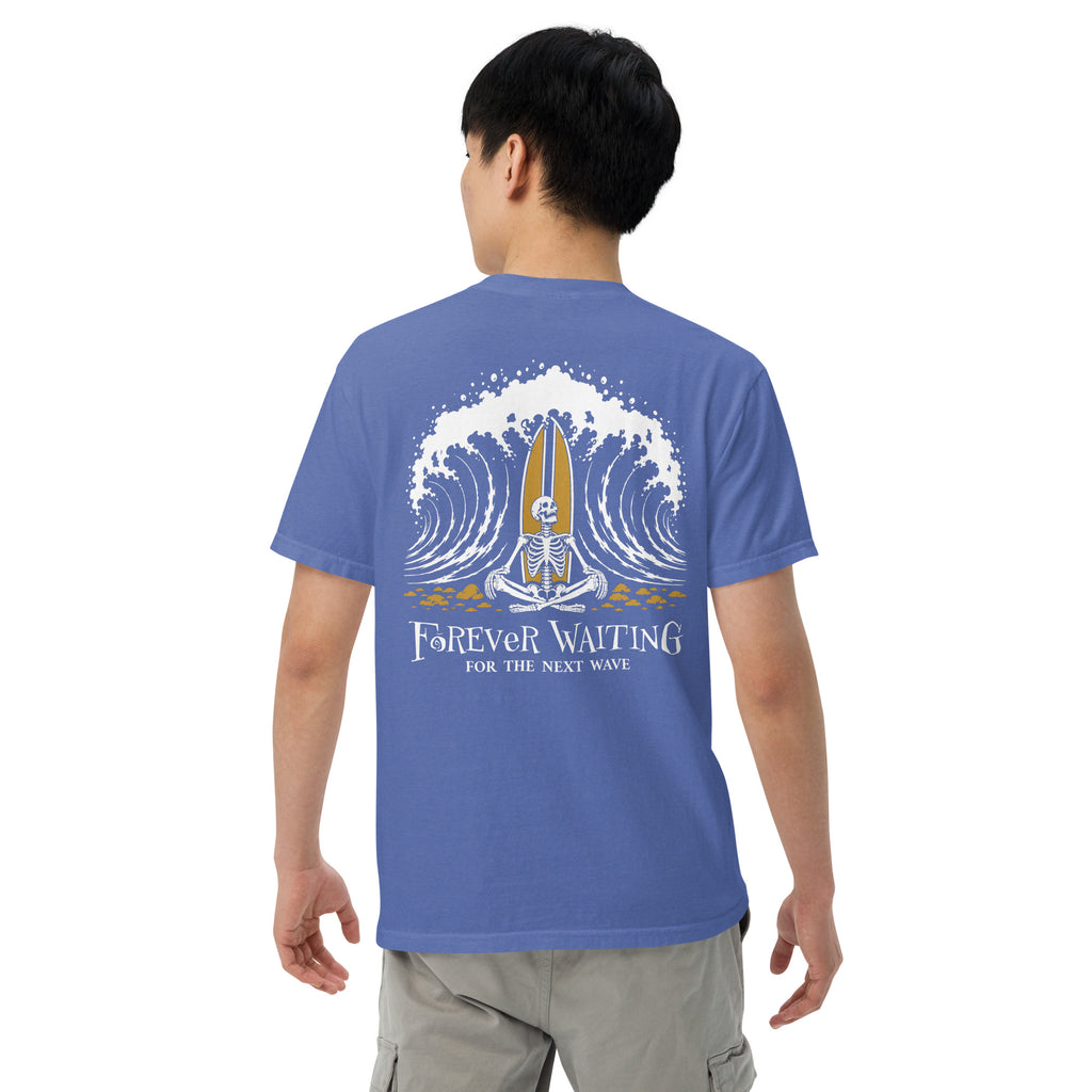 "Forever Waiting For The Next Wave" tee, Mystic Blue, fourth back view, featuring a meditating skeleton surfer, board planted upright behind him, sitting cross-legged on the shore as breakers roll in on either side – 17th & Surf