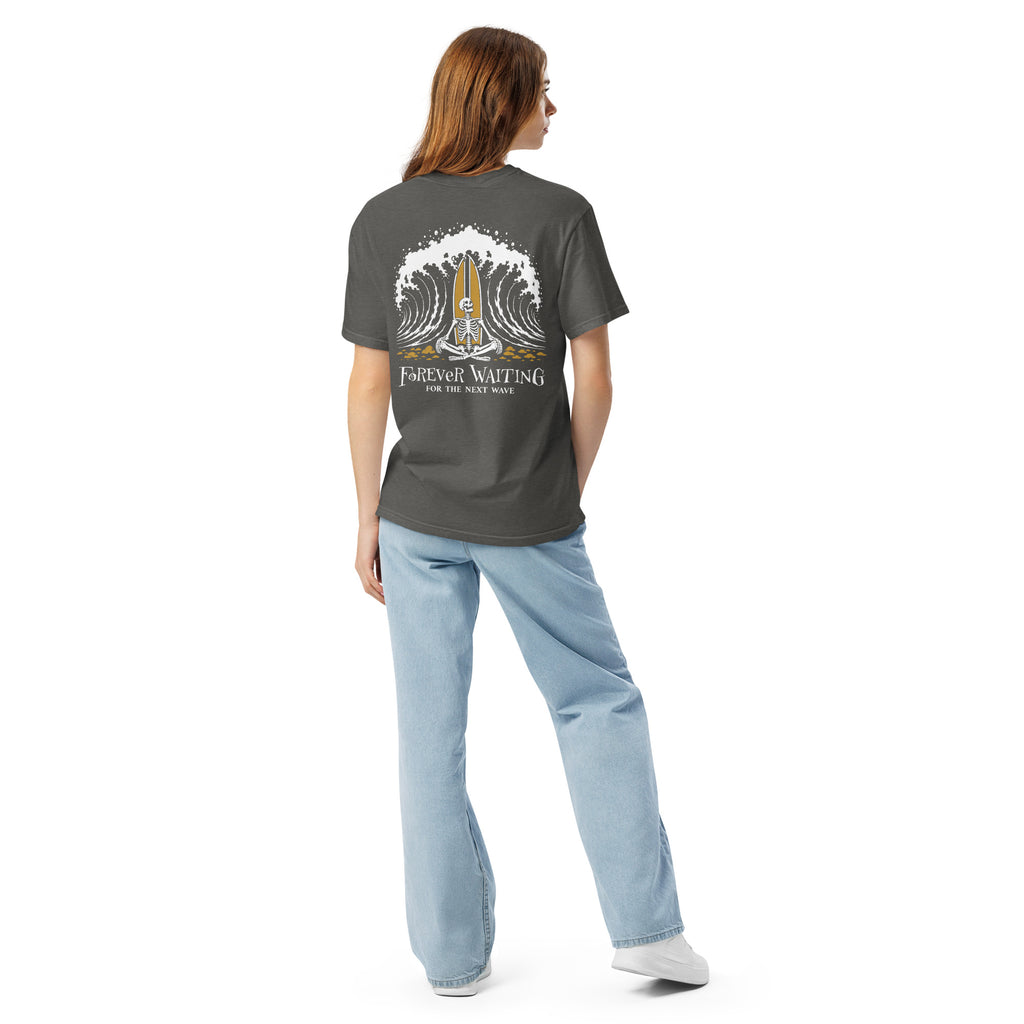 "Forever Waiting For The Next Wave" tee, Pepper, second back view, featuring a meditating skeleton surfer, board planted upright behind him, sitting cross-legged on the shore as breakers roll in on either side – 17th & Surf