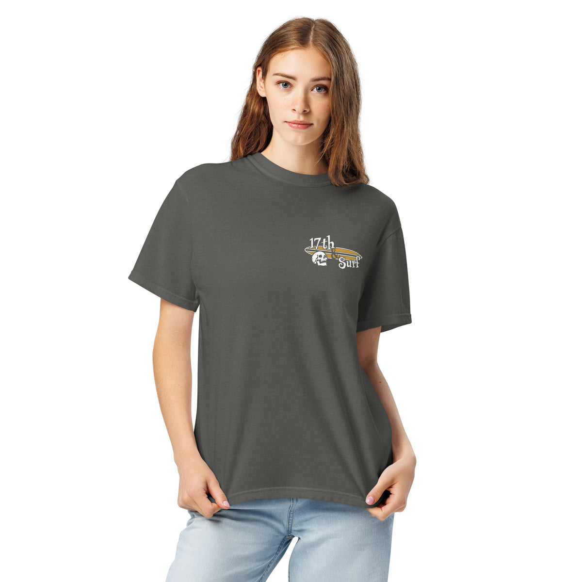 "Forever Waiting For The Next Wave" tee, Pepper, second front view, featuring a meditating skeleton surfer, board planted upright behind him, sitting cross-legged on the shore as breakers roll in on either side – 17th & Surf