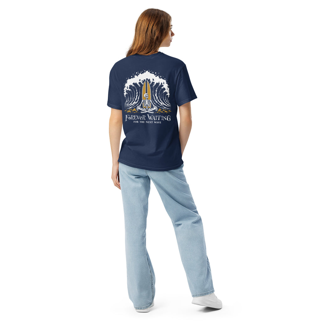 "Forever Waiting For The Next Wave" tee, True Navy, second back view, featuring a meditating skeleton surfer, board planted upright behind him, sitting cross-legged on the shore as breakers roll in on either side – 17th & Surf