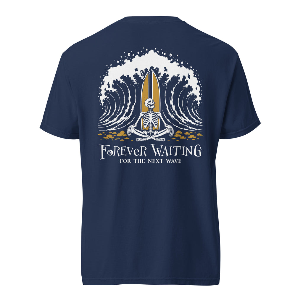 "Forever Waiting For The Next Wave" tee, True Navy, back view, featuring a meditating skeleton surfer, board planted upright behind him, sitting cross-legged on the shore as breakers roll in on either side – 17th & Surf