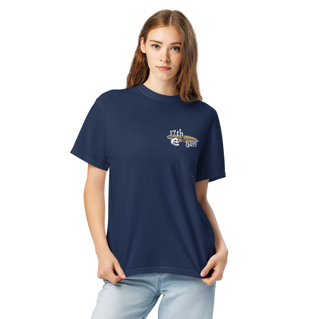 "Forever Waiting For The Next Wave" tee, True Navy, second front view, featuring a meditating skeleton surfer, board planted upright behind him, sitting cross-legged on the shore as breakers roll in on either side – 17th & Surf