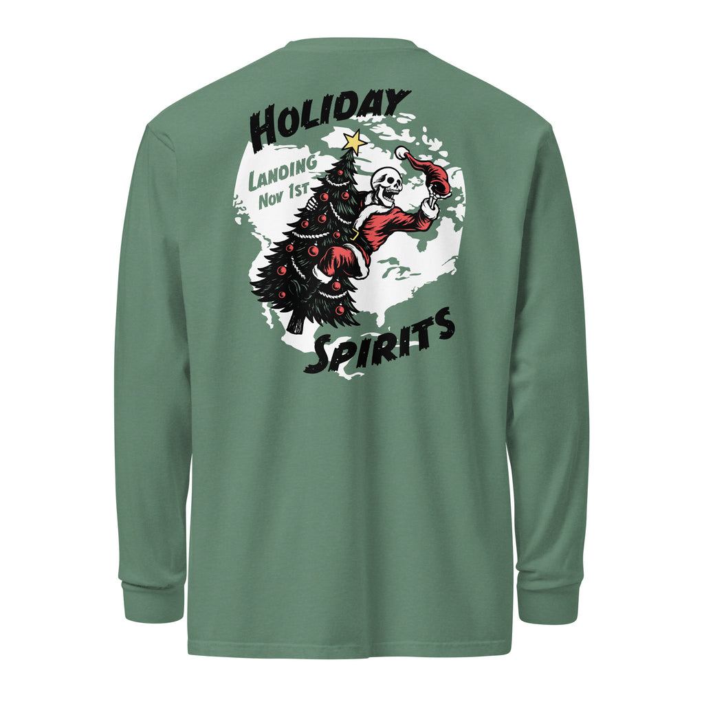 Model wearing "Holiday Spirits" garment-dyed heavyweight long sleeve shirt in sage green, back view featuring full color graphic of a skeleton Santa riding a decorated Christmas tree inside a white splatter map shape with arched "Holiday" and "Spirits" text and "Landing Nov 1st" – 17th & Surf