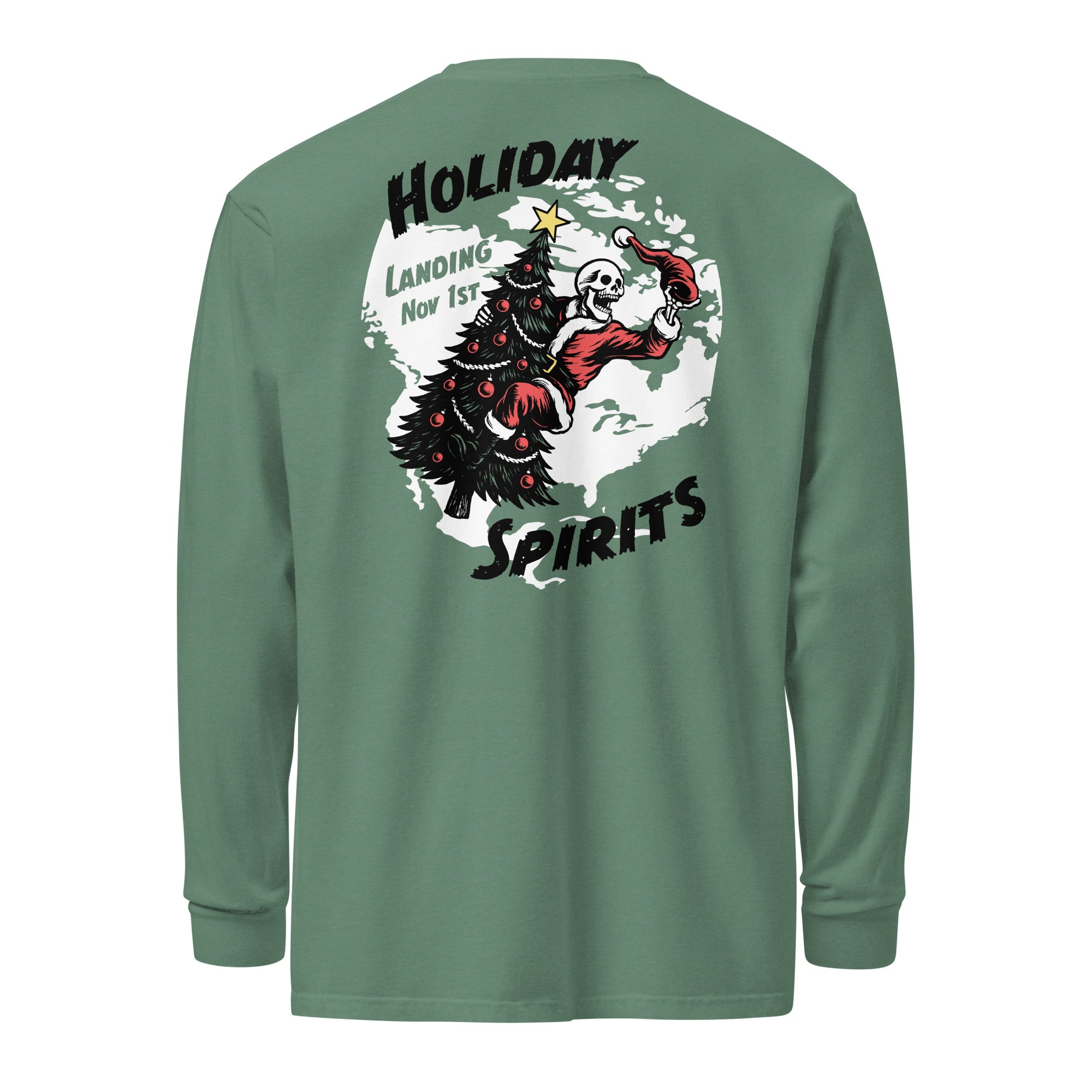 Model wearing "Holiday Spirits" garment-dyed heavyweight long sleeve shirt in sage green, back view featuring full color graphic of a skeleton Santa riding a decorated Christmas tree inside a white splatter map shape with arched "Holiday" and "Spirits" text and "Landing Nov 1st" – 17th & Surf