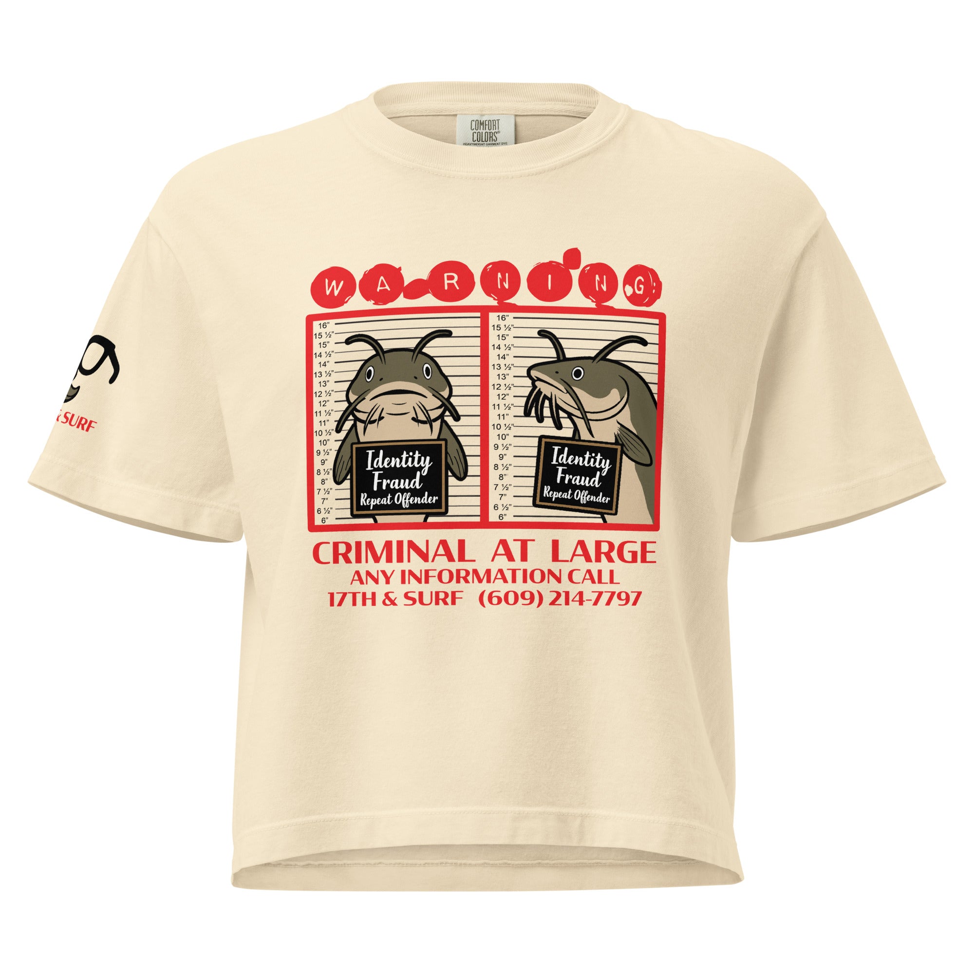 "Identity Fraud" ivory women's heavyweight boxy tee, front view, featuring catfish "WARNING" mugshot graphic with "Identity Fraud, Repeat Offender" police lineup – 17th & Surf