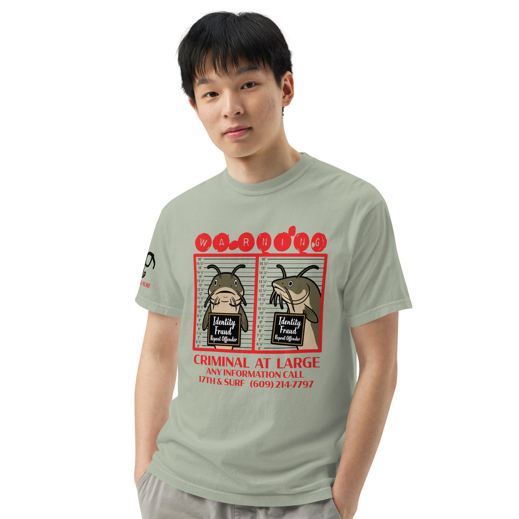 "Identity Fraud" bay garment-dyed heavyweight tee on male model, front view, featuring catfish "WARNING" mugshot graphic with "Identity Fraud, Repeat Offender" police lineup – 17th & Surf