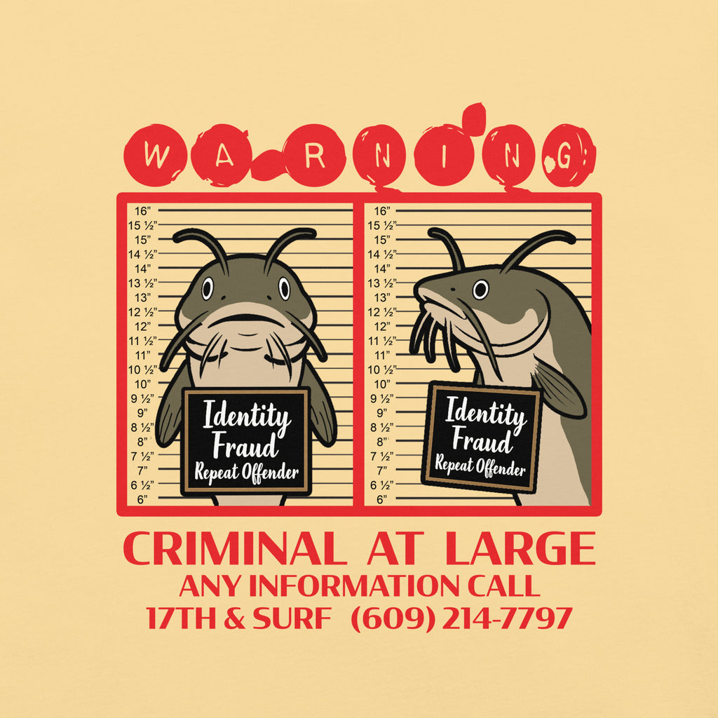 "Identity Fraud" butter garment-dyed heavyweight tee, close-up of catfish "WARNING" mugshot graphic with "Identity Fraud, Repeat Offender" police lineup – 17th & Surf