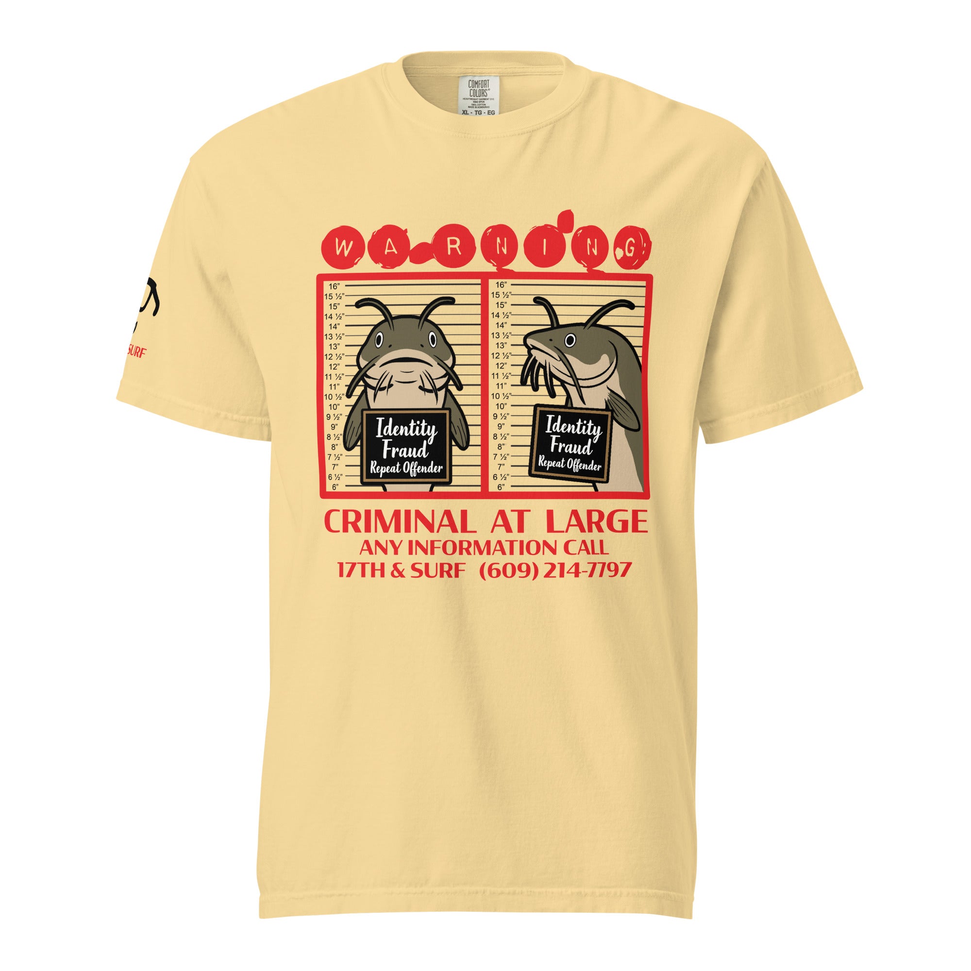 "Identity Fraud" butter garment-dyed heavyweight tee, front flat lay, featuring catfish "WARNING" mugshot graphic with "Identity Fraud, Repeat Offender" police lineup – 17th & Surf