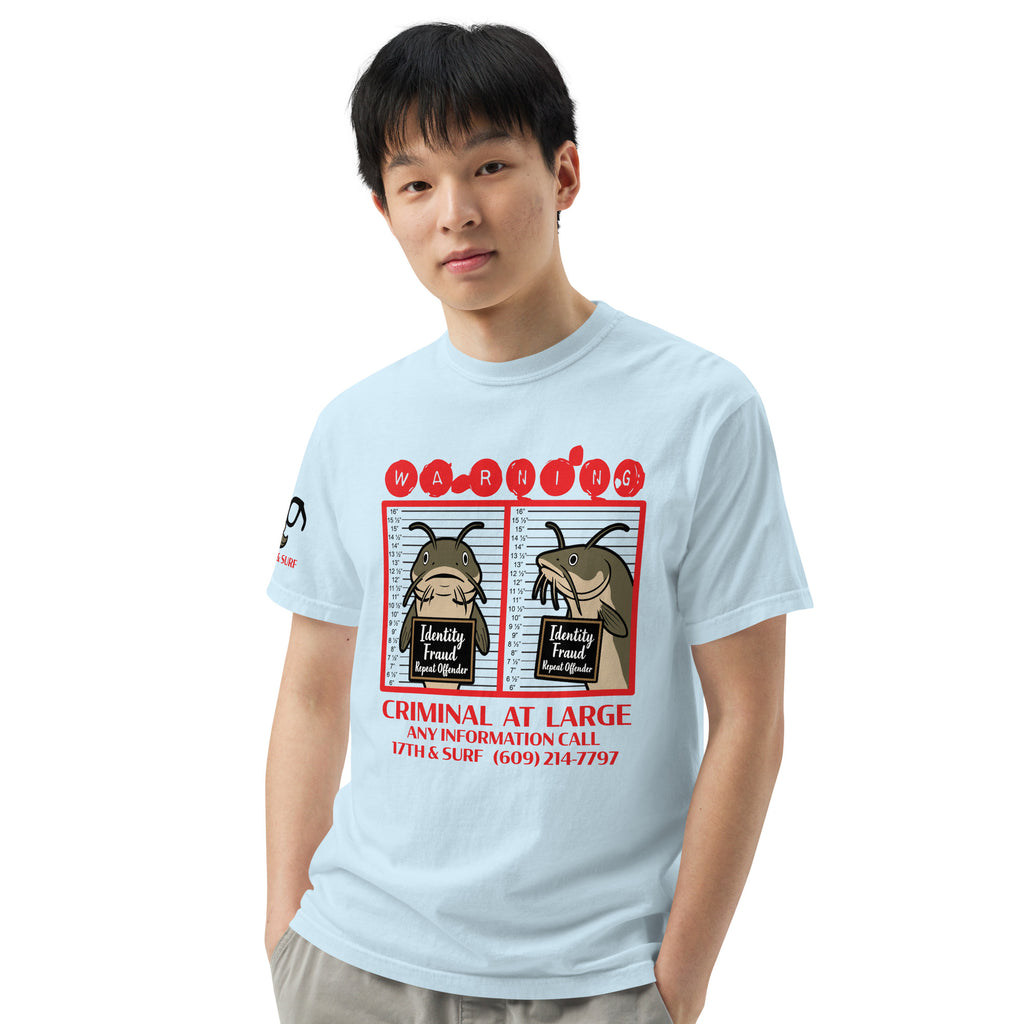 "Identity Fraud" chambray garment-dyed heavyweight tee on male model, front view, featuring catfish "WARNING" mugshot graphic with "Identity Fraud, Repeat Offender" police lineup – 17th & Surf