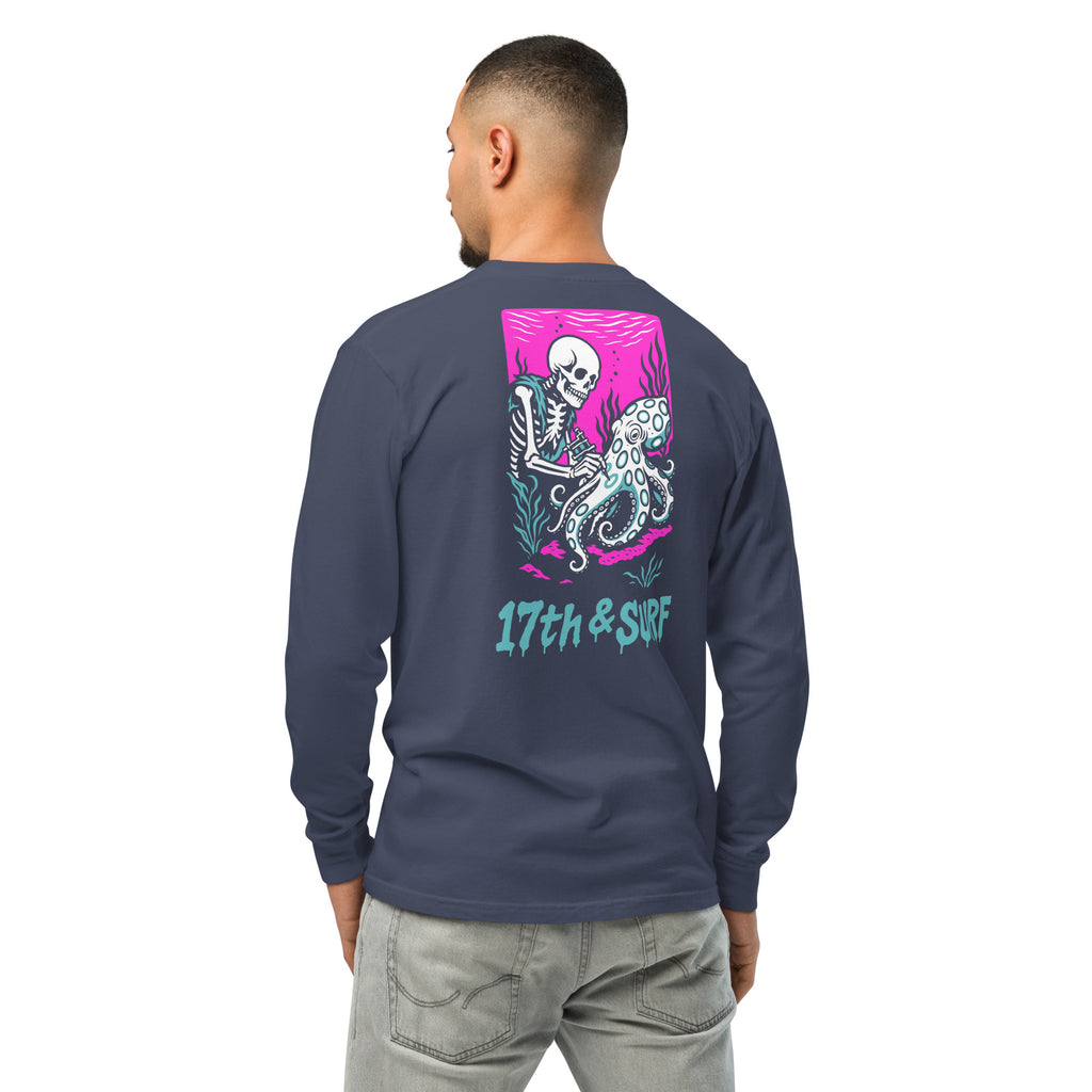 "Inked" garment-dyed heavyweight long sleeve back view in true navy featuring skeleton tattooing an octopus graphic with "17th & Surf" text on pink background – 17th & Surf