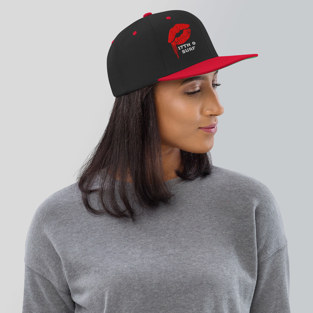 Model wearing the 17th & Surf Kiss snapback hat, black and red with a red dripping lips graphic and "17TH & SURF" text – 17th & Surf