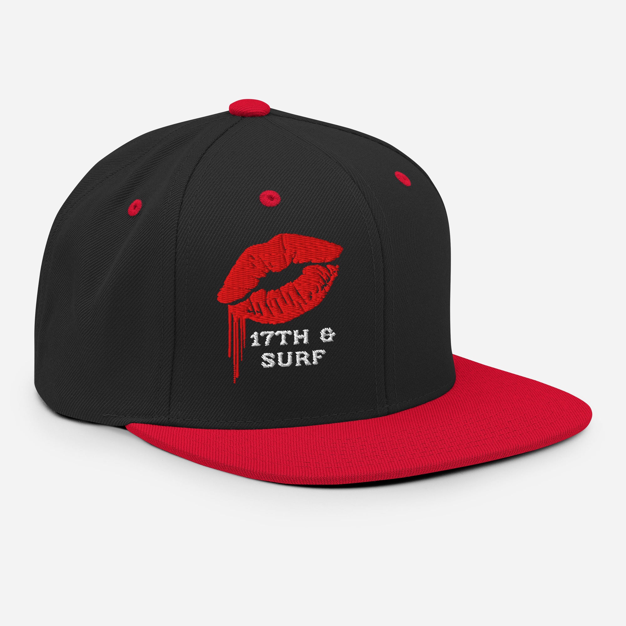 17th & Surf Kiss snapback hat three-quarter angle view showing the red dripping lips graphic and red brim – 17th & Surf