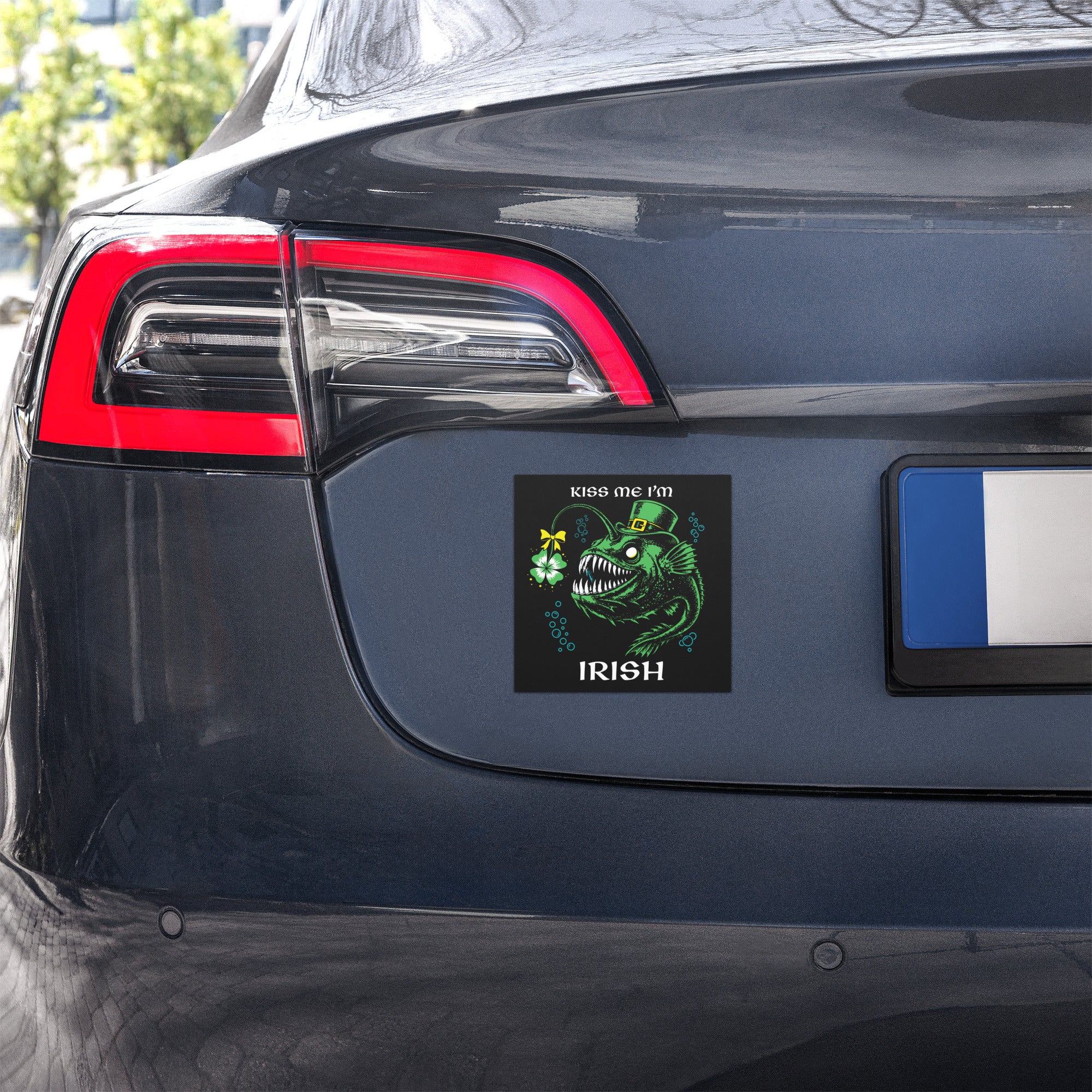 "Kiss Me I'm Irish" Anglerfish car magnet shown on a vehicle's rear bumper, featuring the green leprechaun anglerfish with shamrock lure and "KISS ME I'M IRISH" text – 17th & Surf