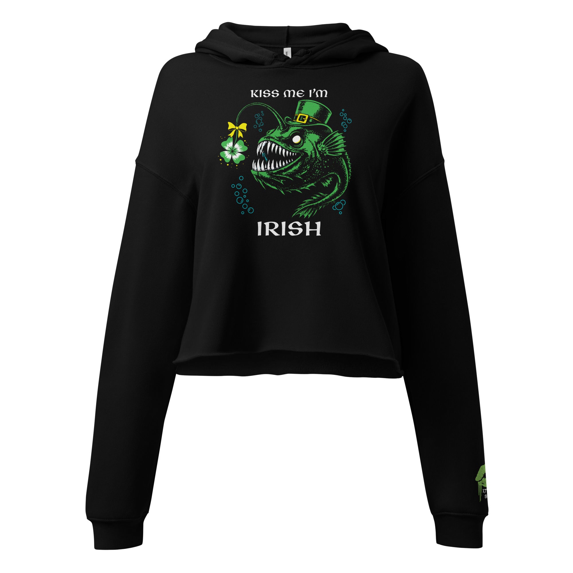 "Kiss Me I'm Irish" Anglerfish black cropped hoodie, front flat lay, featuring the green leprechaun anglerfish with shamrock lure and "KISS ME I'M IRISH" text on the chest, plus a dripping-lips "17TH & SURF" logo on the sleeve cuff – 17th & Surf