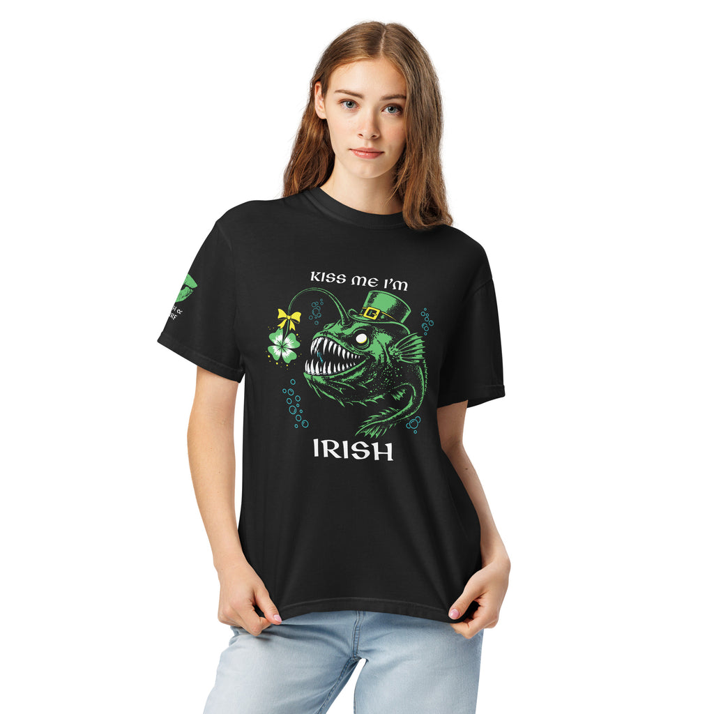"Kiss Me I'm Irish" Anglerfish black tee on female model, front view, featuring the green leprechaun anglerfish with shamrock lure and "KISS ME I'M IRISH" text, plus a dripping-lips "17TH & SURF" sleeve logo – 17th & Surf