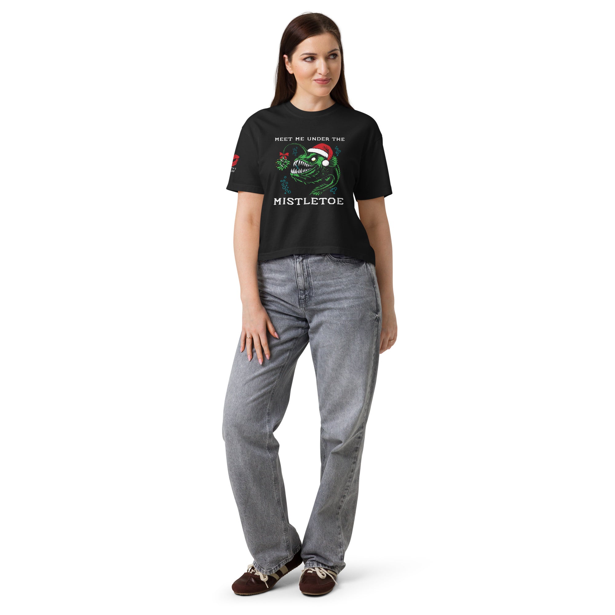 "Mistletoe" Anglerfish black heavyweight boxy t-shirt on female model, front view, featuring a green anglerfish wearing a Santa hat with mistletoe and "Meet Me Under The Mistletoe" graphic – 17th & Surf