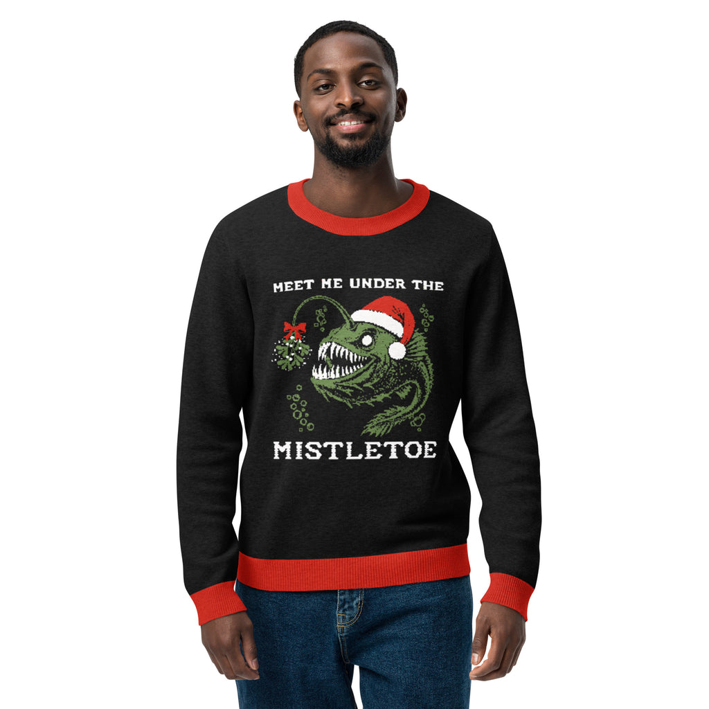 "Mistletoe" Anglerfish charcoal knitted Christmas sweater with red ribbed trim on male model, front view, featuring a green anglerfish wearing a Santa hat with mistletoe and "Meet Me Under The Mistletoe" graphic – 17th & Surf