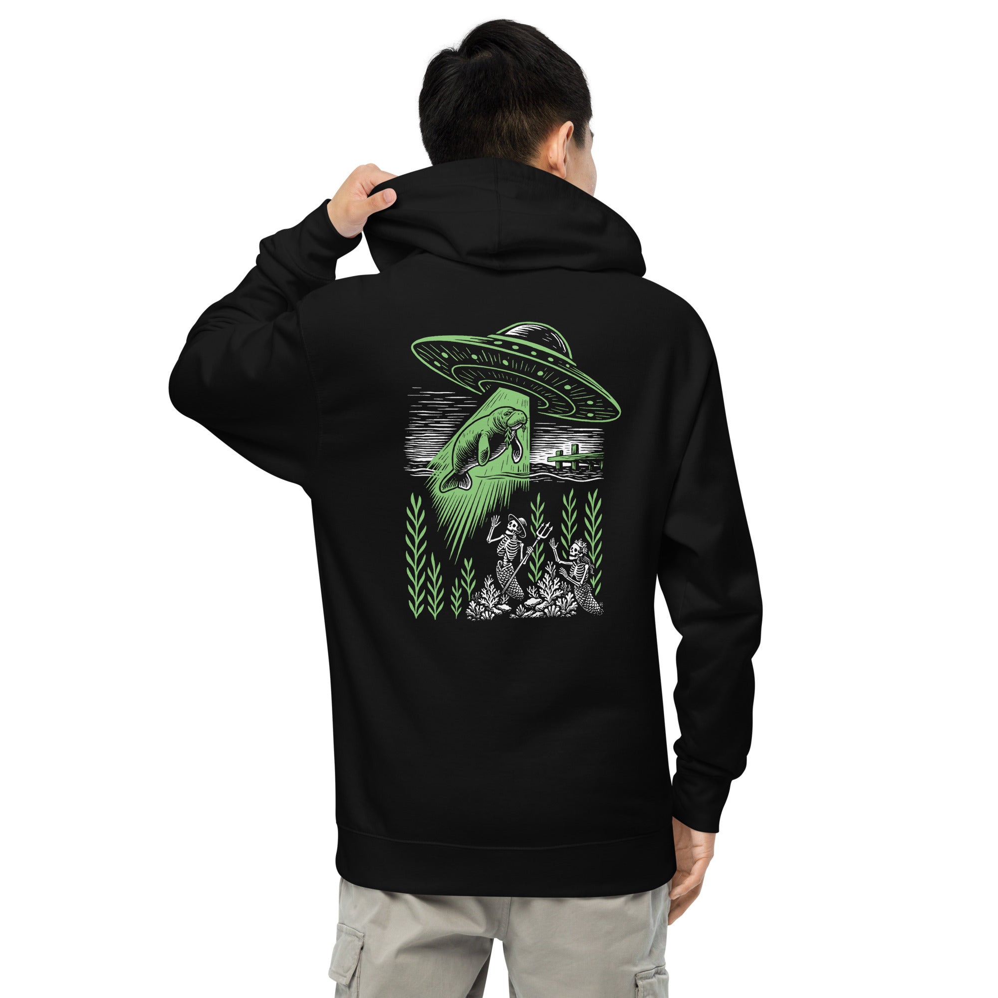 "Ocean Abduction" garment-dyed heavyweight hoodie, male model back view, featuring UFO abducting a manatee via tractor beam over skeleton mermaids design – 17th & Surf