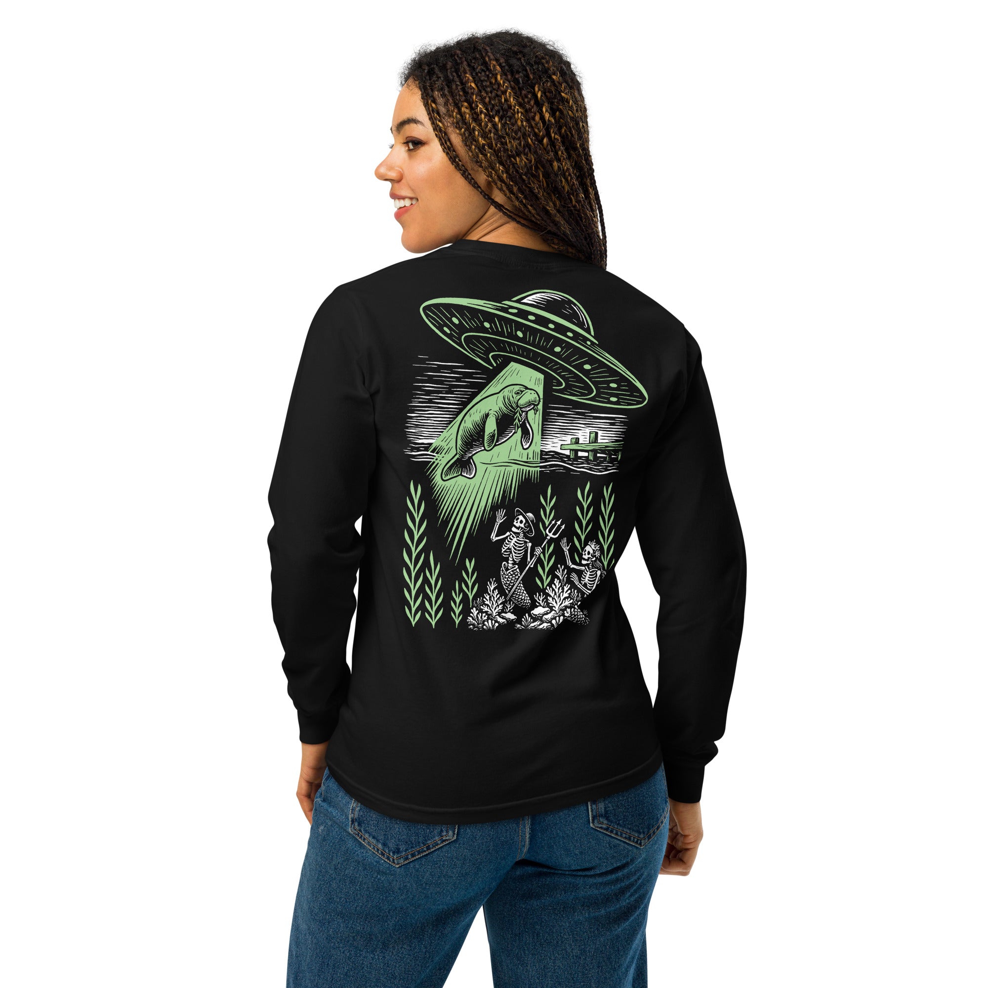 "Ocean Abduction" garment-dyed heavyweight long sleeve shirt, female model back view, featuring UFO abducting a manatee via tractor beam over skeleton mermaids design – 17th & Surf