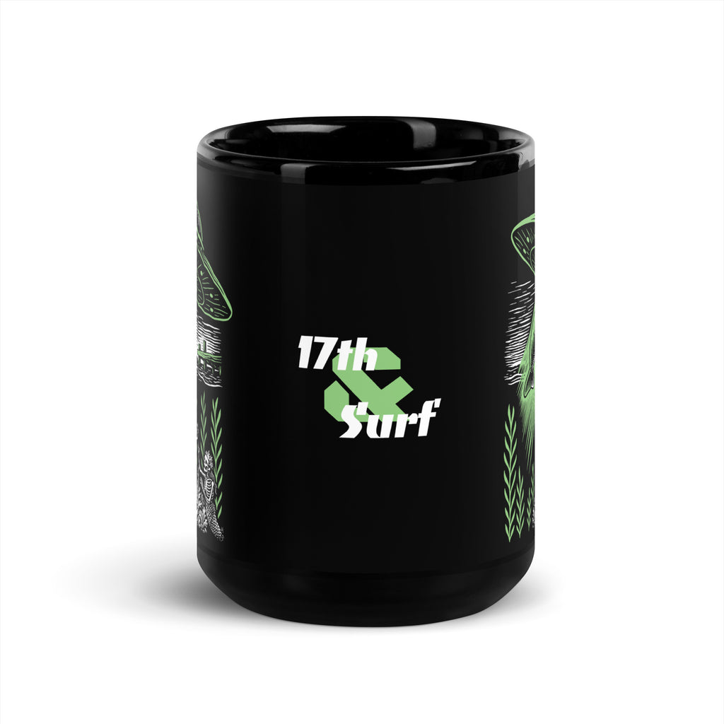"Ocean Abduction" black glossy 15oz mug, front view, featuring "17th & Surf" logo with UFO abduction graphic wrapping the mug – 17th & Surf