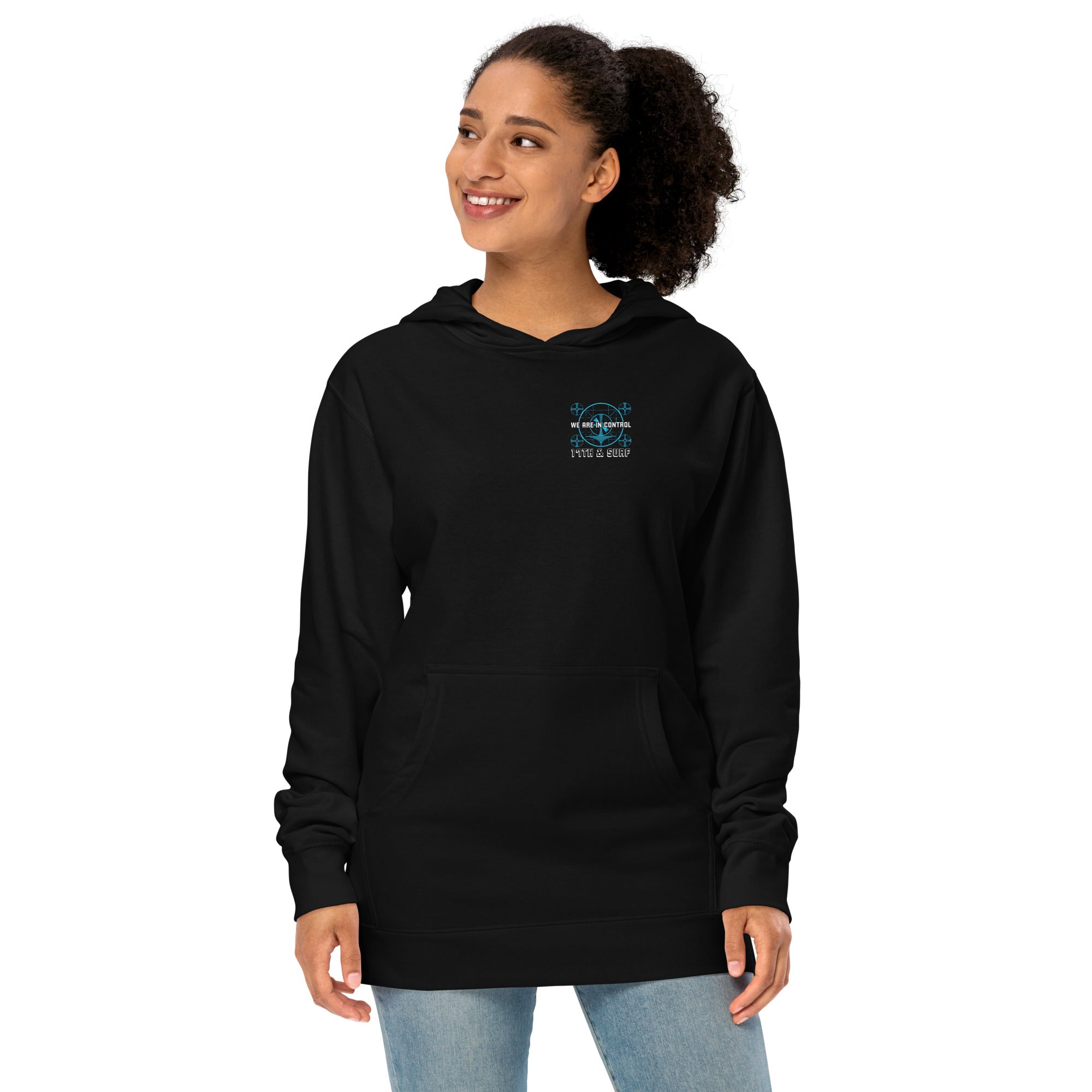 "Beneath The Outer Limits" unisex midweight hoodie in black, front view on female model, featuring the small blue "WE ARE IN CONTROL" broadcast test-pattern chest logo with "17th & Surf" text – "Beneath The Outer Limits" Series by 17th & Surf