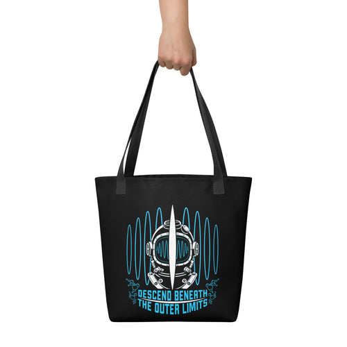 "Beneath The Outer Limits" black all-over print tote bag, held by hand, featuring the large graphic of a vintage diving helmet split by a surfboard fin, framed by blue broadcast test-pattern rings with an oscillating waveform, rising bubbles, and the text "DESCEND BENEATH THE OUTER LIMITS" – "Beneath The Outer Limits" Series by 17th & Surf