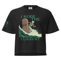 "RIP Current" women's heavyweight boxy tee in black, front view showing skeleton surfing a "RIP" tombstone "I Rode the Current" graphic and "17TH & SURF" sleeve emblem – 17th & Surf