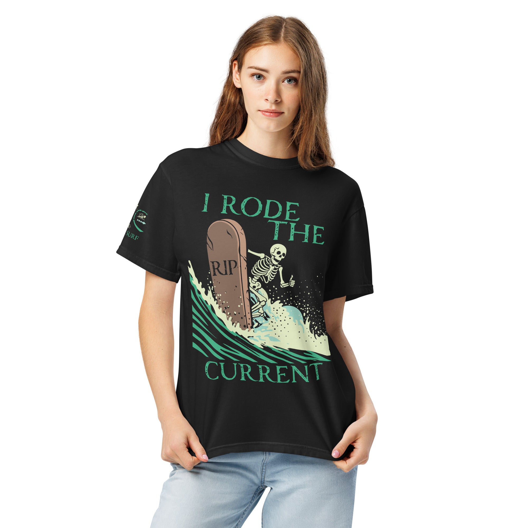 Model wearing "RIP Current" front print garment-dyed heavyweight tee in black with full skeleton surfing a "RIP" tombstone "I Rode the Current" graphic on front – 17th & Surf