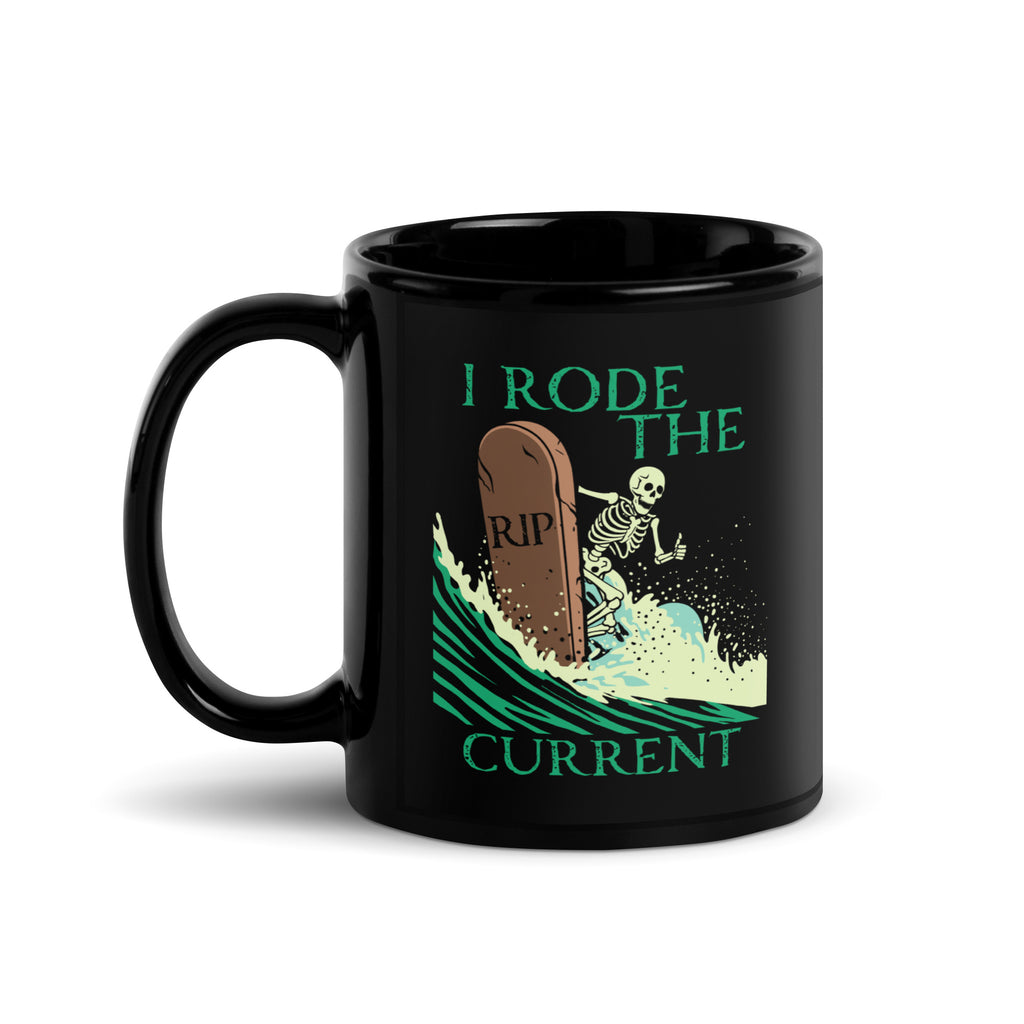 "RIP Current" black glossy 11oz mug with handle on left, featuring skeleton surfing a "RIP" tombstone "I Rode the Current" graphic – 17th & Surf